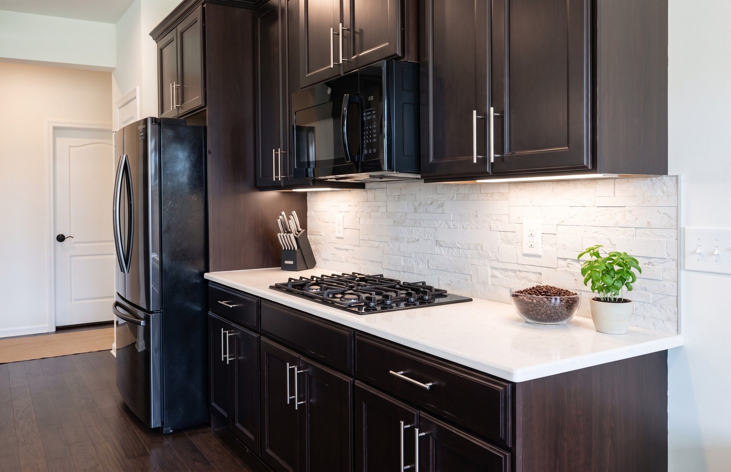 Fully appointed culinary workspace with gas range, double wall ovens, and ample cabinetry for long-term stays.