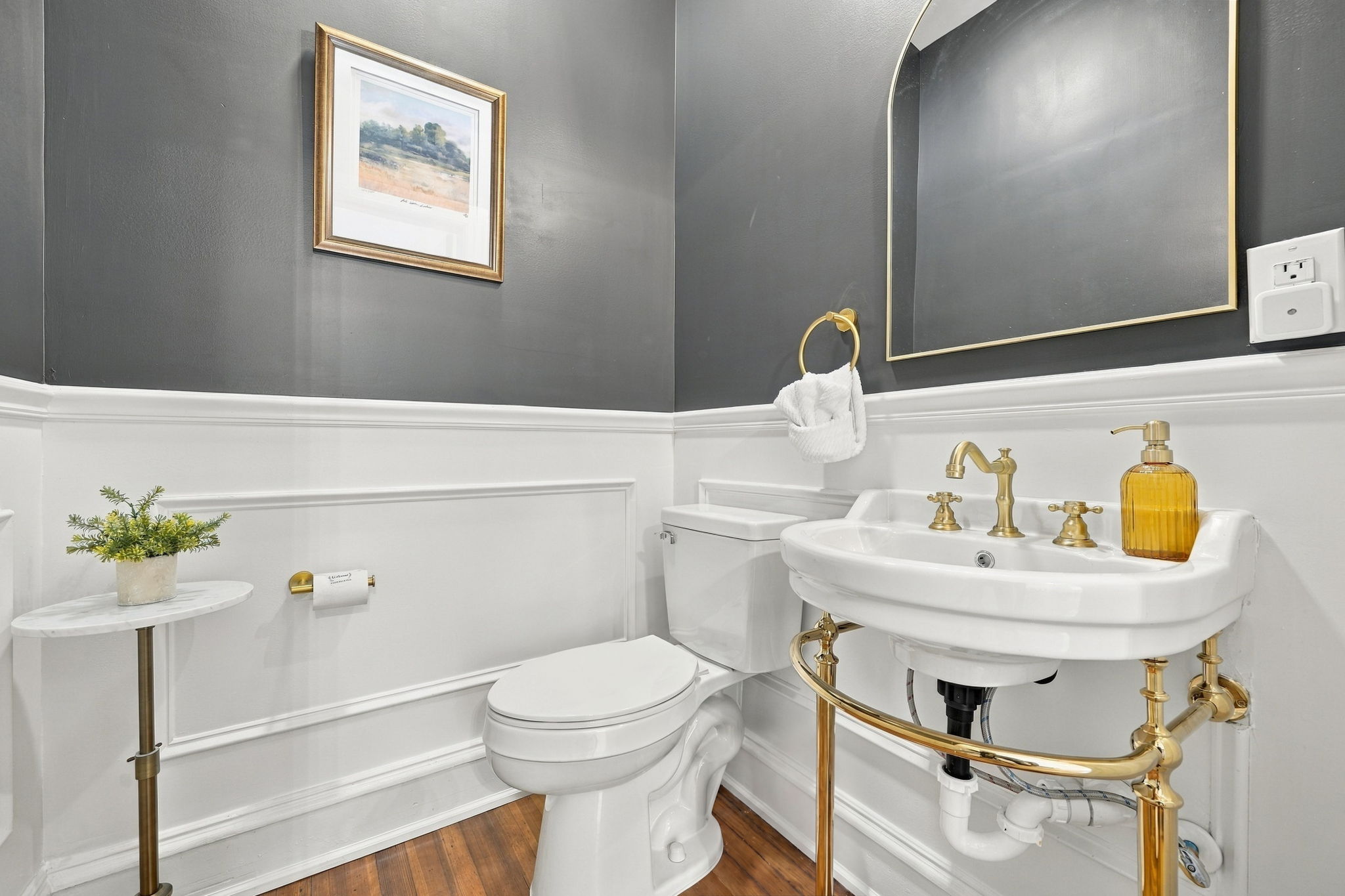 Half Bath: Chic gray walls and gold accents create a stylish space for freshening up!