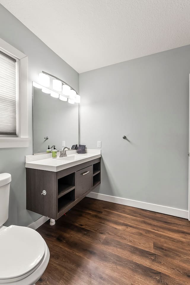 Spacious bathroom layout with modern finishes, bright lighting, and easy access to laundry facilities.