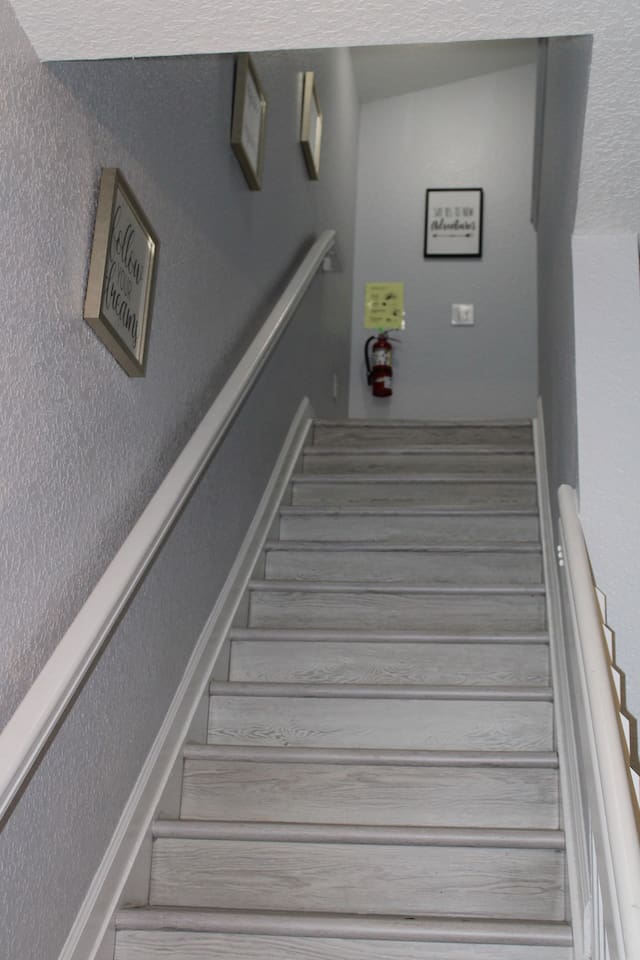 - Stairway with soft gray walls and motivational art for an inviting ascent  
- Wide steps and railing provide safety and ease for all guests  
- Leads to cozy upstairs bedrooms and additional living spaces  
