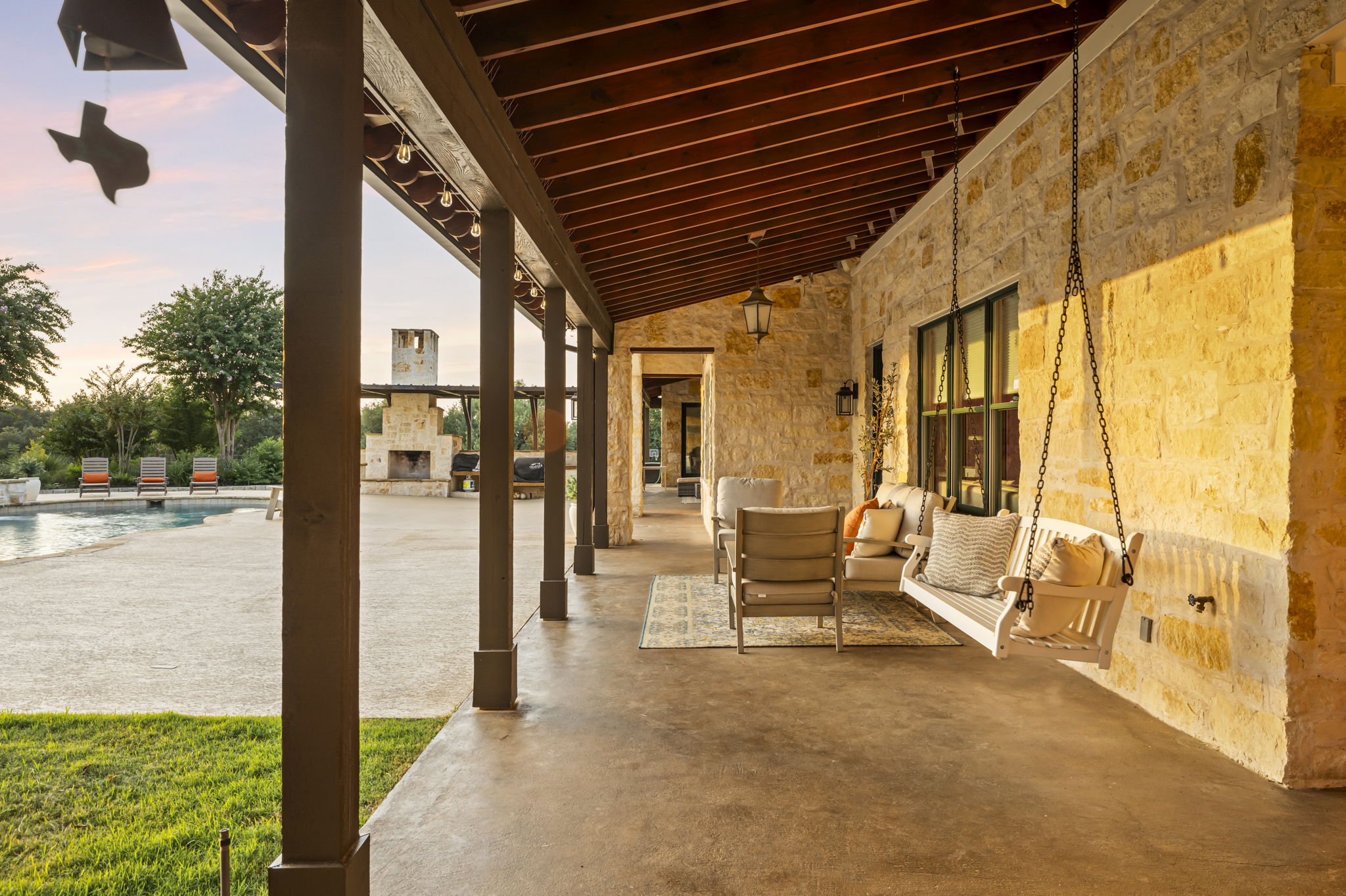 A tranquil hanging chair inviting relaxation on a spacious stone patio, perfect for enjoying the outdoors.