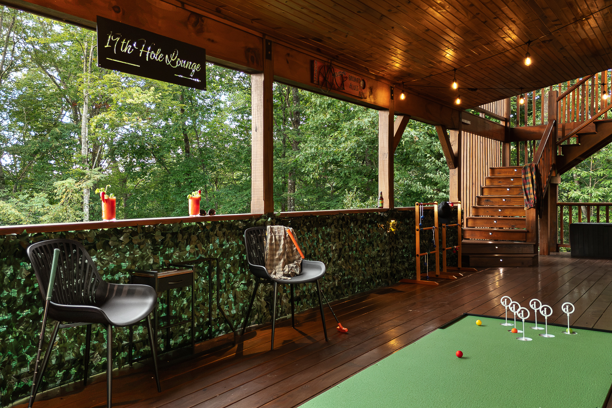 {19th Hole Deck} Play a round of mini golf, pull up a stool, and enjoy the forest views from this covered game deck.