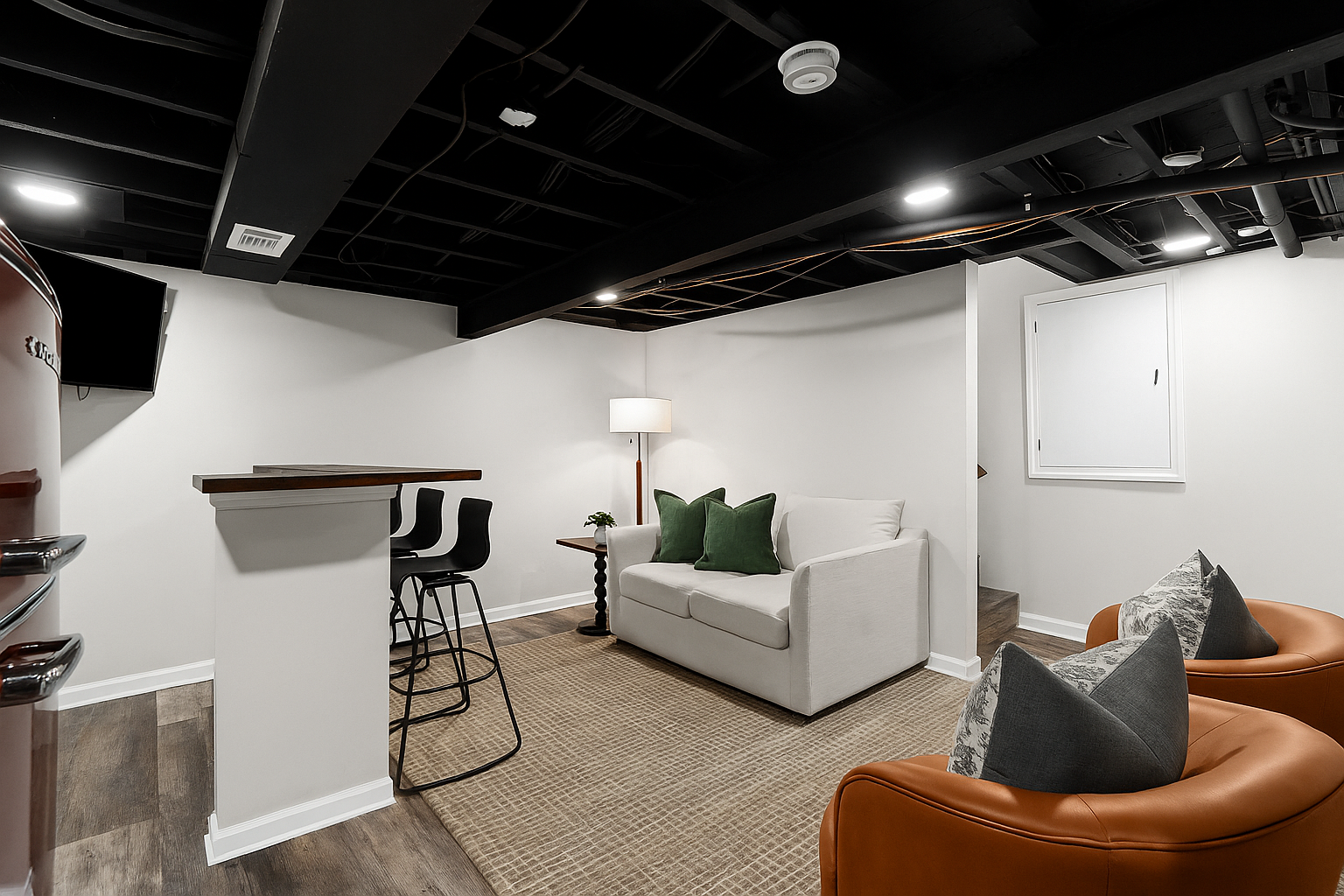 Cozy basement nook with bar seating, pullout sofa, and lounge chairs—ideal for movie nights or extra guests.