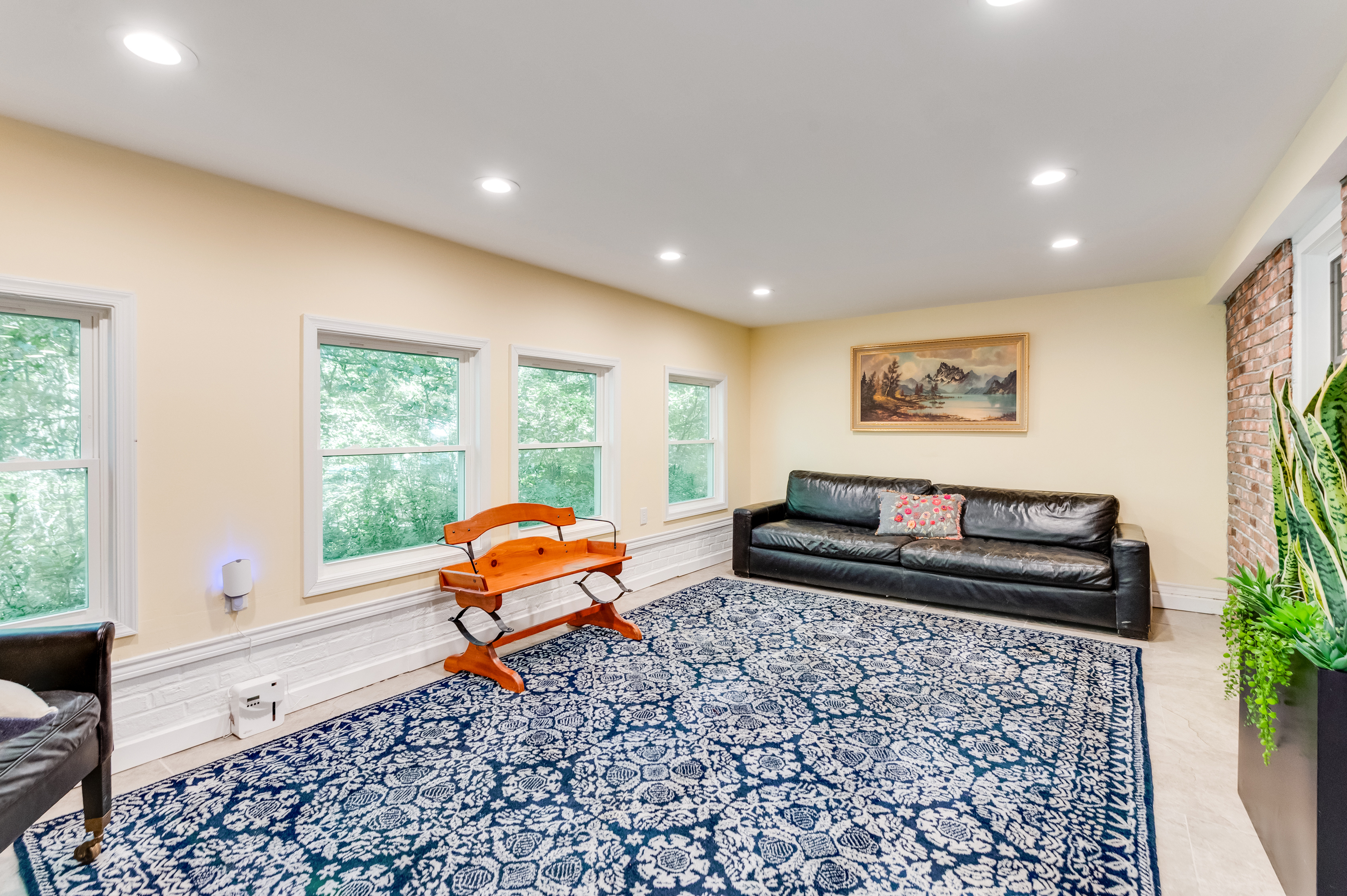 Downstairs Sun Room: Sunlit space with comfy furniture and serene nature views awaits your relaxation!