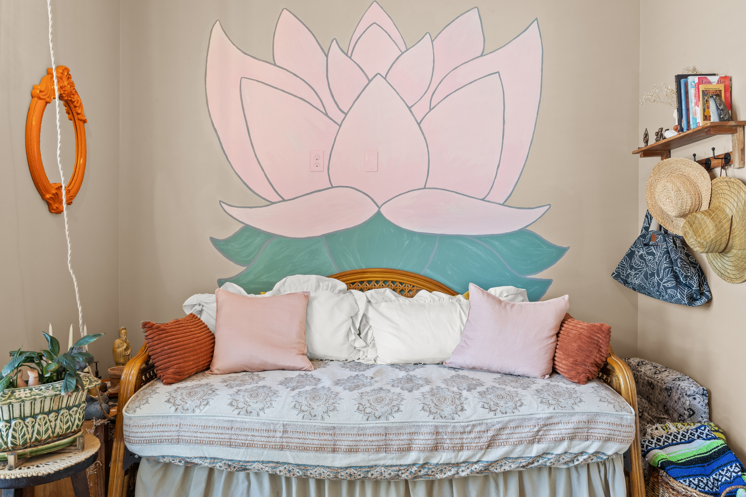 Boho‑inspired daybed room with hand‑painted lotus mural — a serene space to relax.
