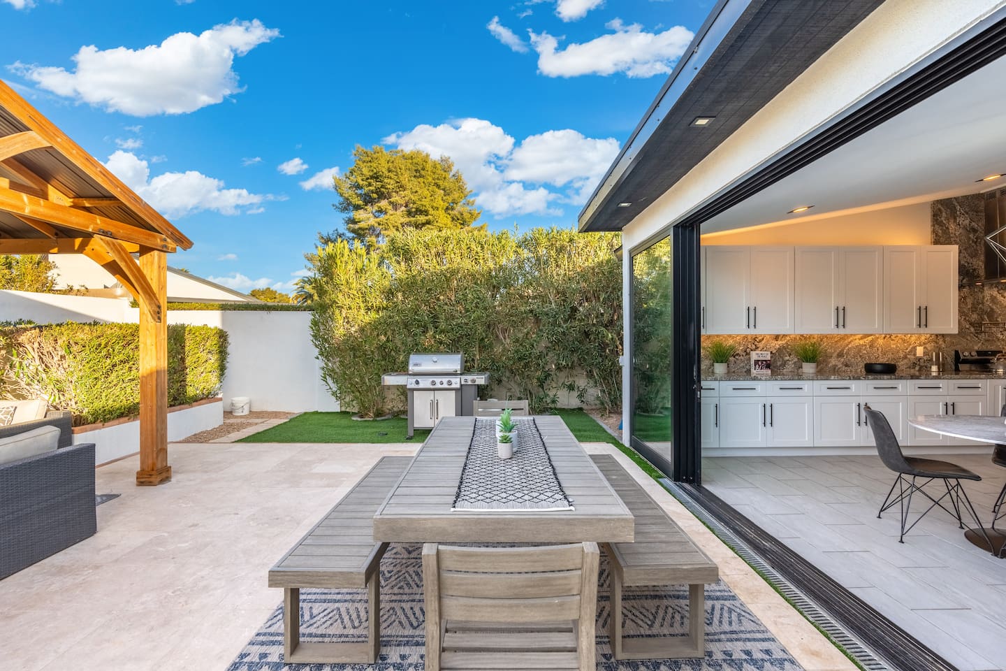 The alfresco dining setup and stainless steel BBQ grill are perfectly positioned just outside the sliding doors — ideal for seamless indoor-outdoor entertaining.