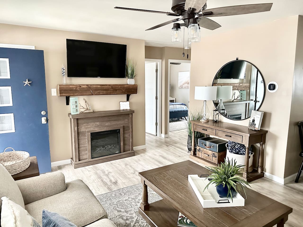 Relax in our beautifully designed living area, featuring a cozy electric fireplace and a large flat-screen TV. The room offers a warm, inviting atmosphere with rustic wood accents, comfortable seating, and a stylish console area—perfect for winding down af