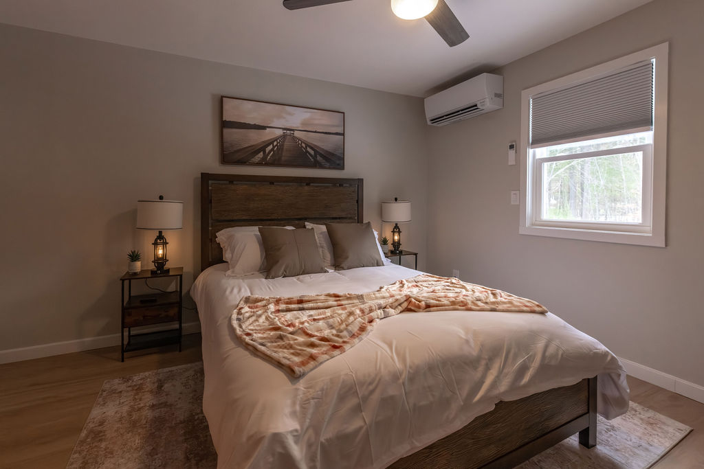Main level bedroom with a queen sized mattress and side tables. 