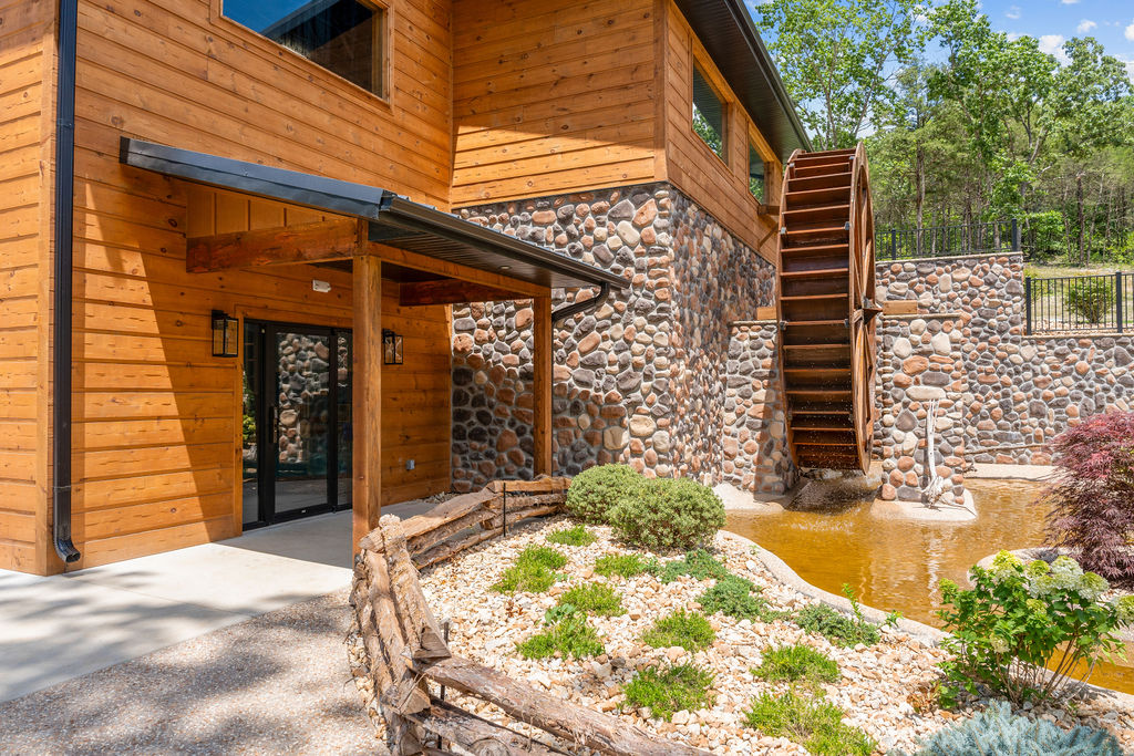 A rustic water wheel and stone mill add Ozark character to the camp's landscaped grounds.