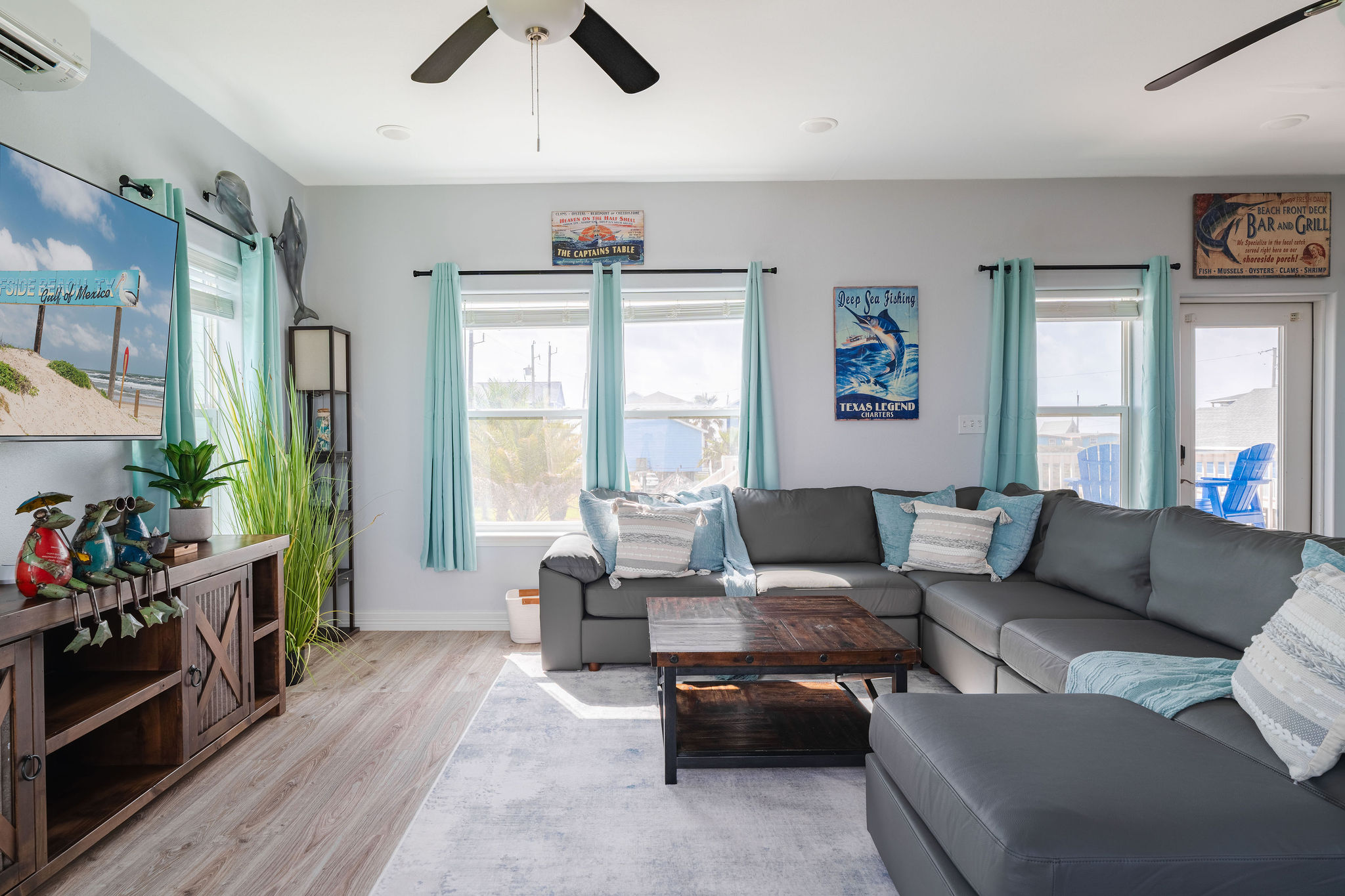 Living room from the deck side — Gulf-facing windows pour in light, deck chairs just steps outside