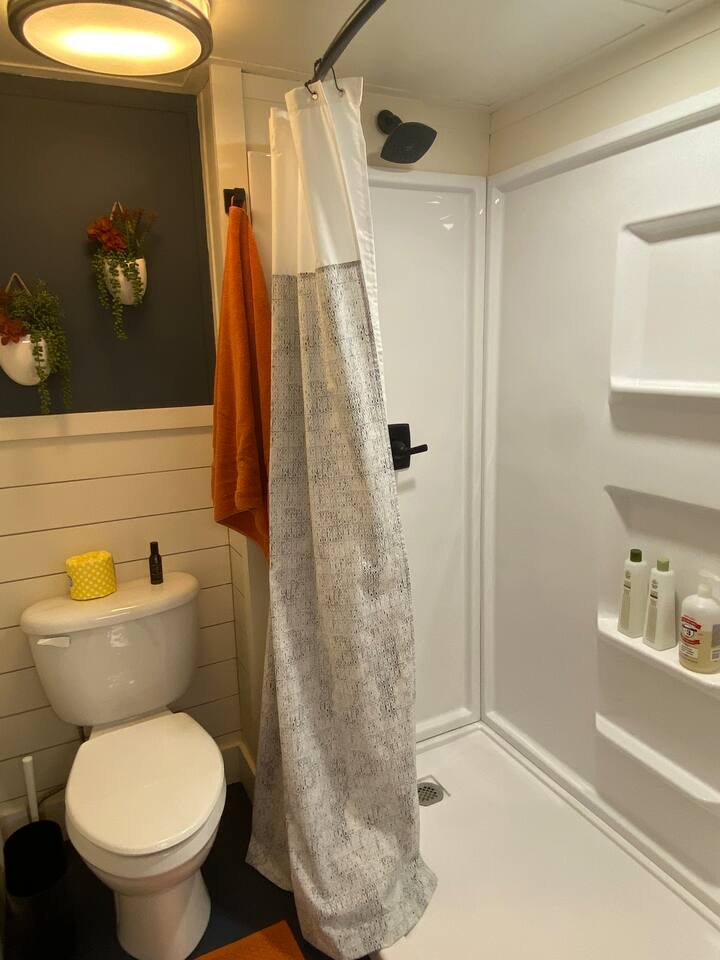 New bathroom with large walk-in shower, toilet, barn door closure and plenty of hooks for towels, robe and belongings. Large sink in laundry room with bright light to help you get ready!