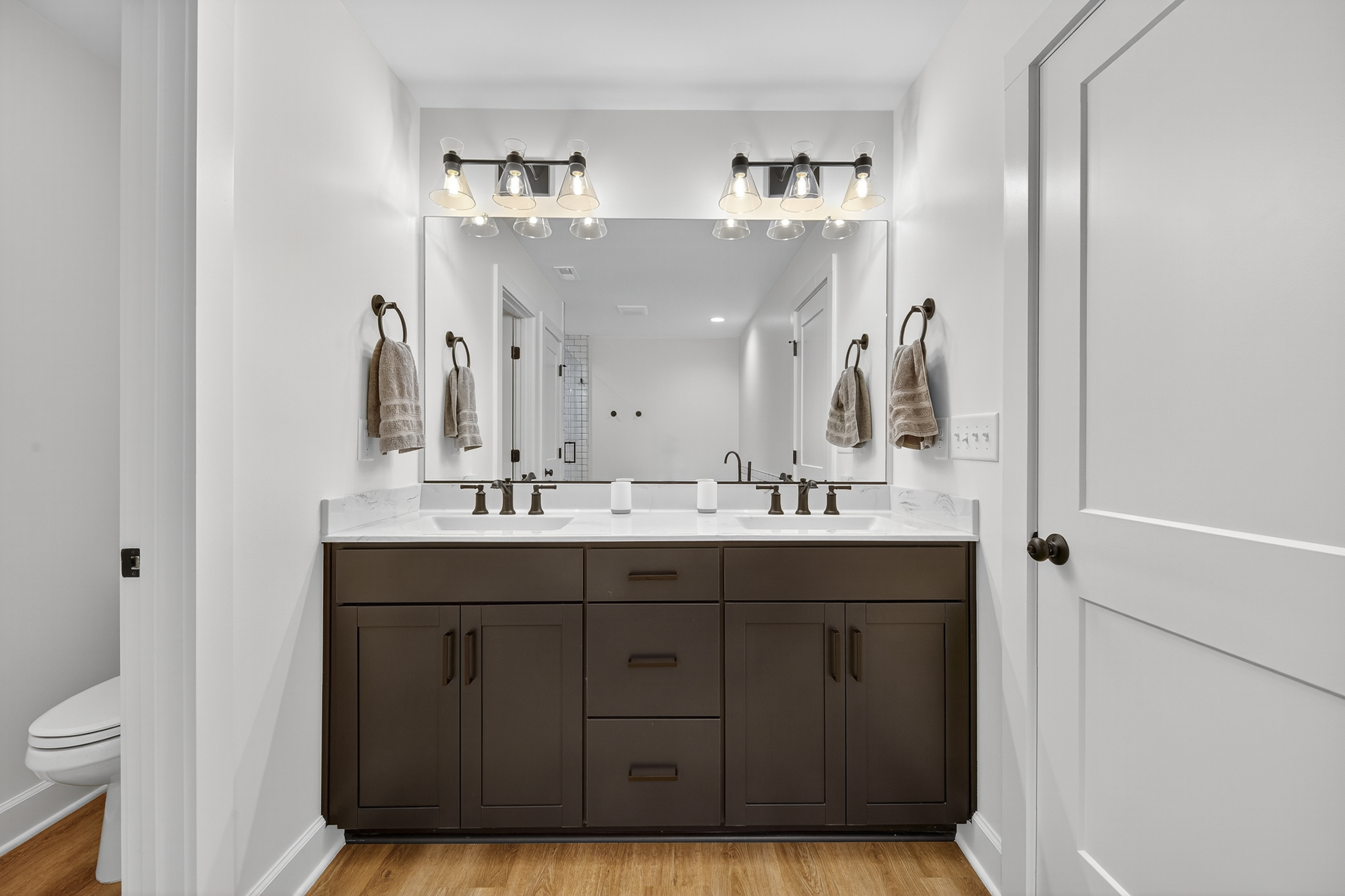 A luxurious escape featuring dual vanities, warm lighting, and sophisticated tile work—perfect for both daily routines and pampering moments.