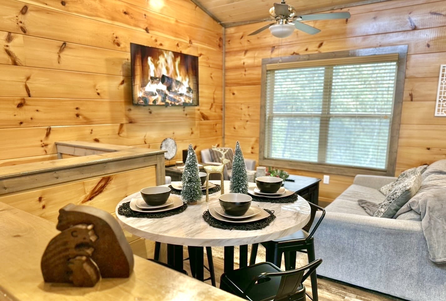 Share a holiday meal beneath the soft glow of the fireplace, surrounded by rustic charm and a space designed for connection and comfort.