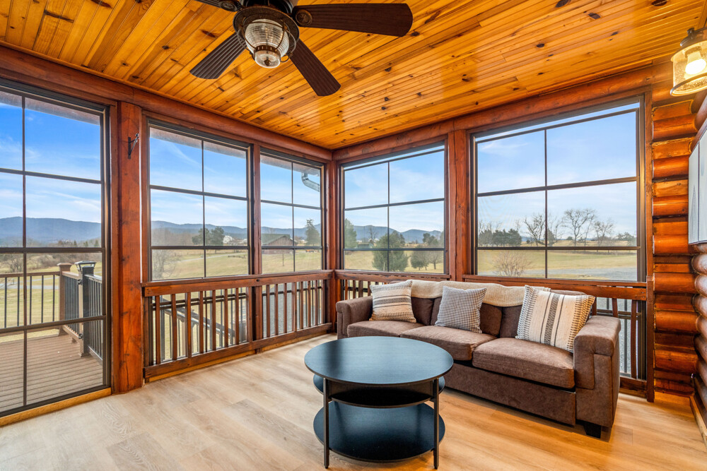 Bright sunroom with wraparound windows, cozy seating, and stunning mountain views—perfect for morning coffee or sunset relaxing.