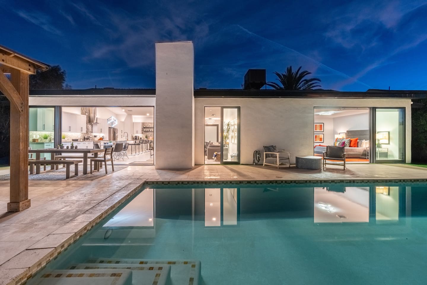 As evening falls, the backyard transforms into a magical oasis with glowing reflections and ambient lighting.