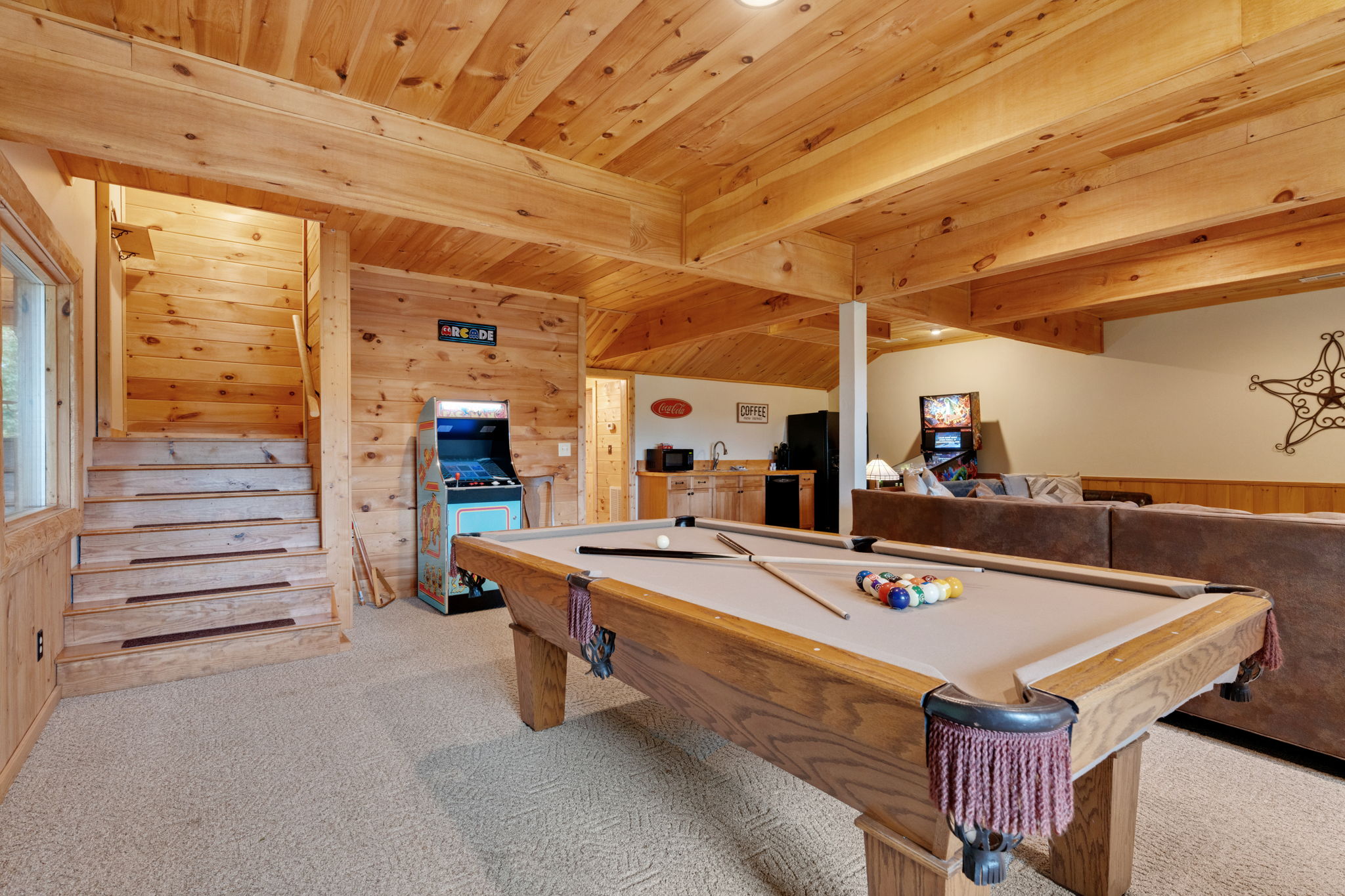 Game room with pool table, sectional sofa, tv, pinball and classic arcade game.  Plus a kitchenette for keeping drinks and food nearby.