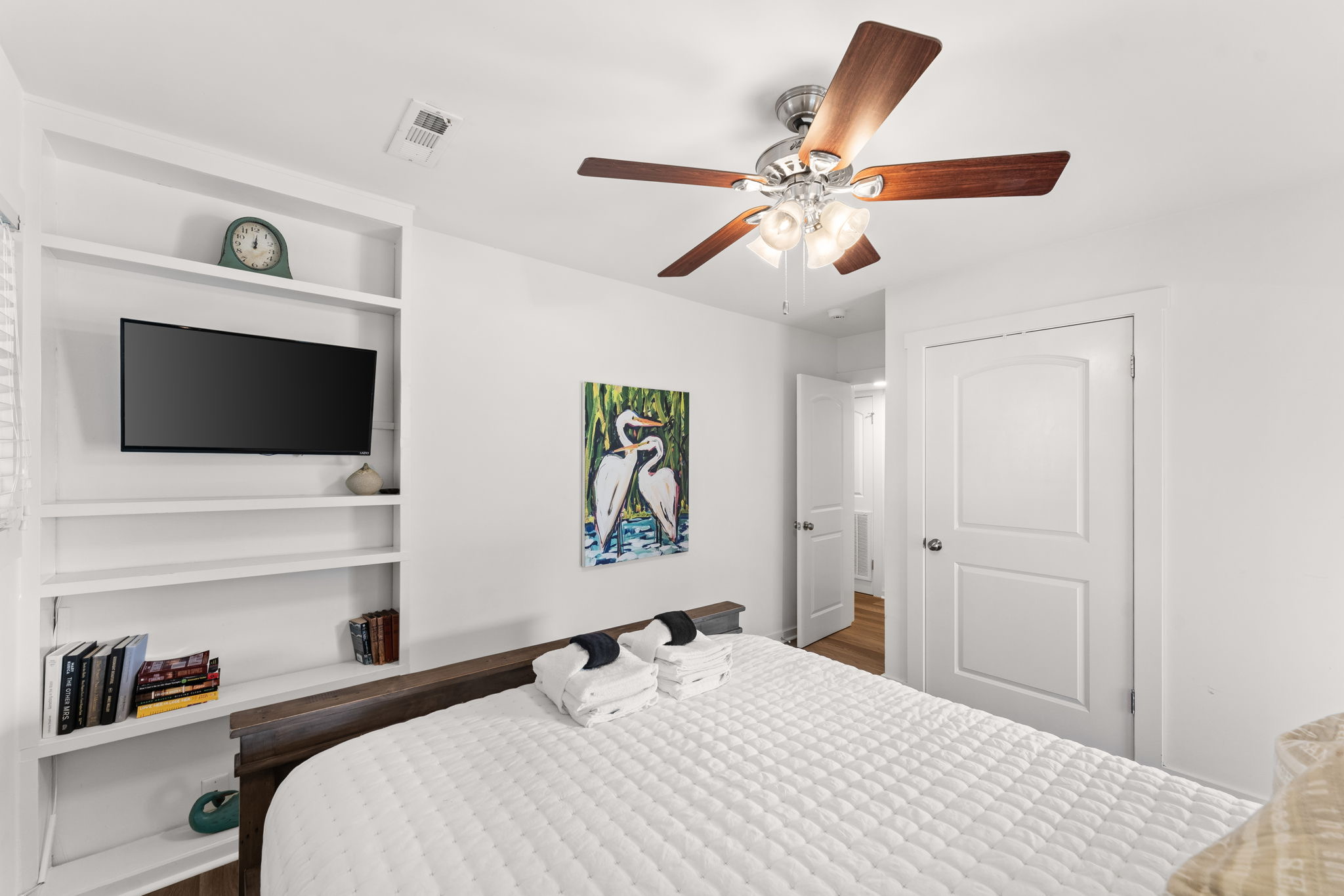 Side A, 3rd Floor: A peaceful guest room with a plush Queen bed, ceiling fan and smart TV.