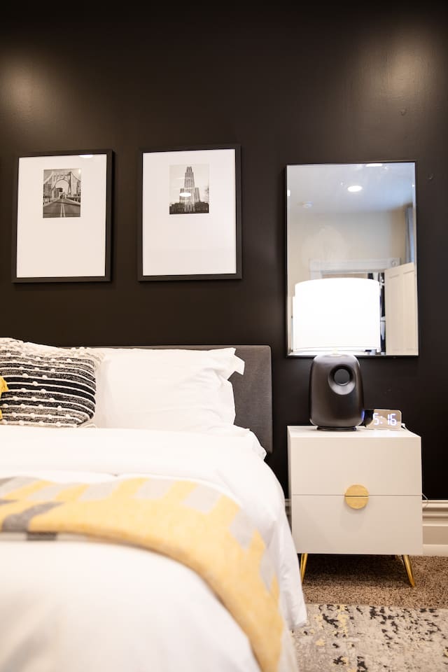 A cozy king-sized bed with soft, inviting linens, positioned beside a large window that lets in natural light, offering a peaceful and serene atmosphere.