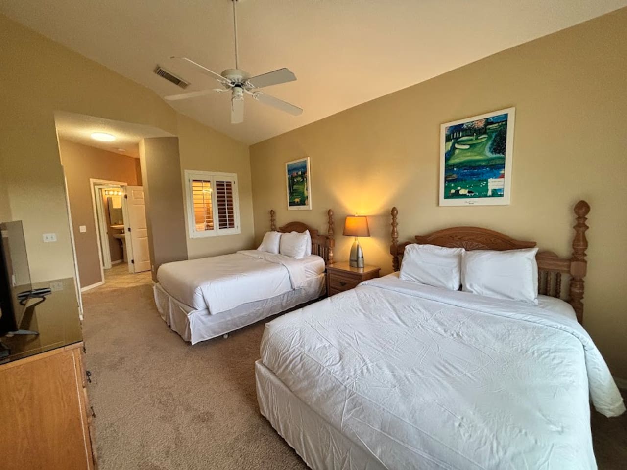 Comfortable bedroom with two beds, ceiling fan, bedside lighting, and a relaxing layout.