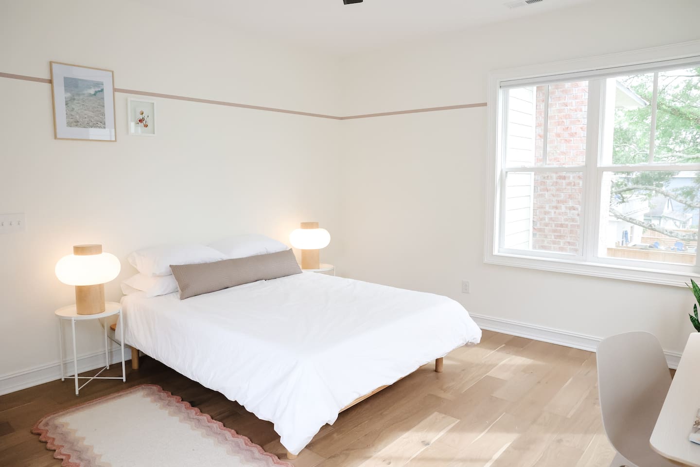 The "rose room" features a queen bed, accents from CB2, a desk for work-from-home, smart TV, a spacious double-door closet and a full bath with a shower tub. 