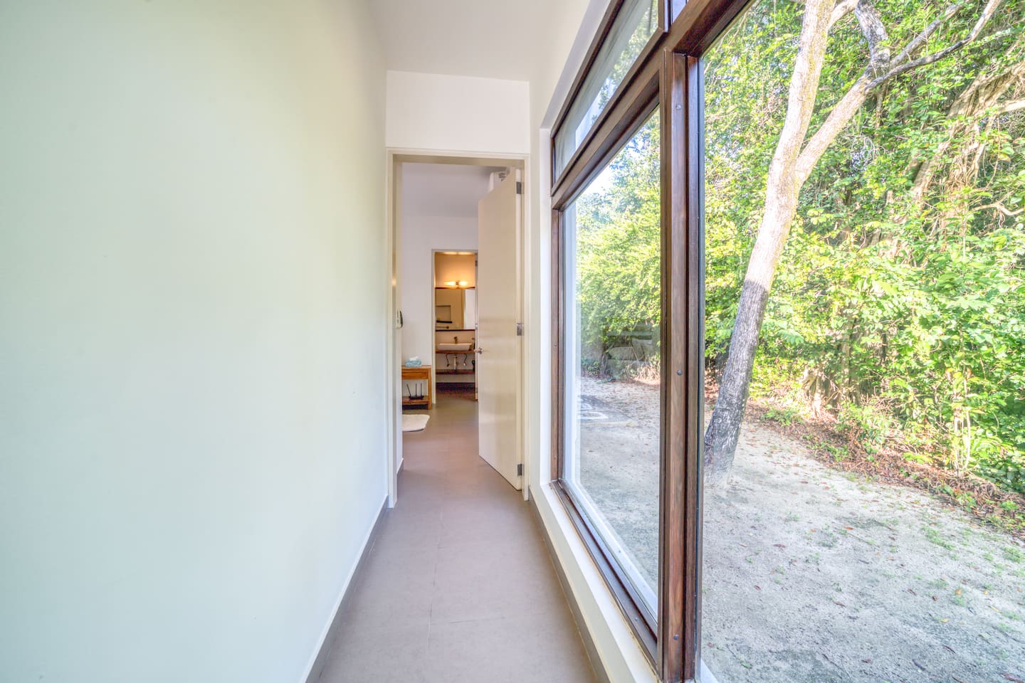 Over-sized windows in the passageway offer beautiful views of the lush greenery surrounding the Villa