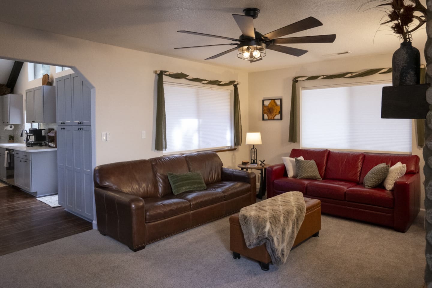 Comfortable living room with sofa seating that turns queen pullout, ceiling fan, and easy access to the kitchen. 
