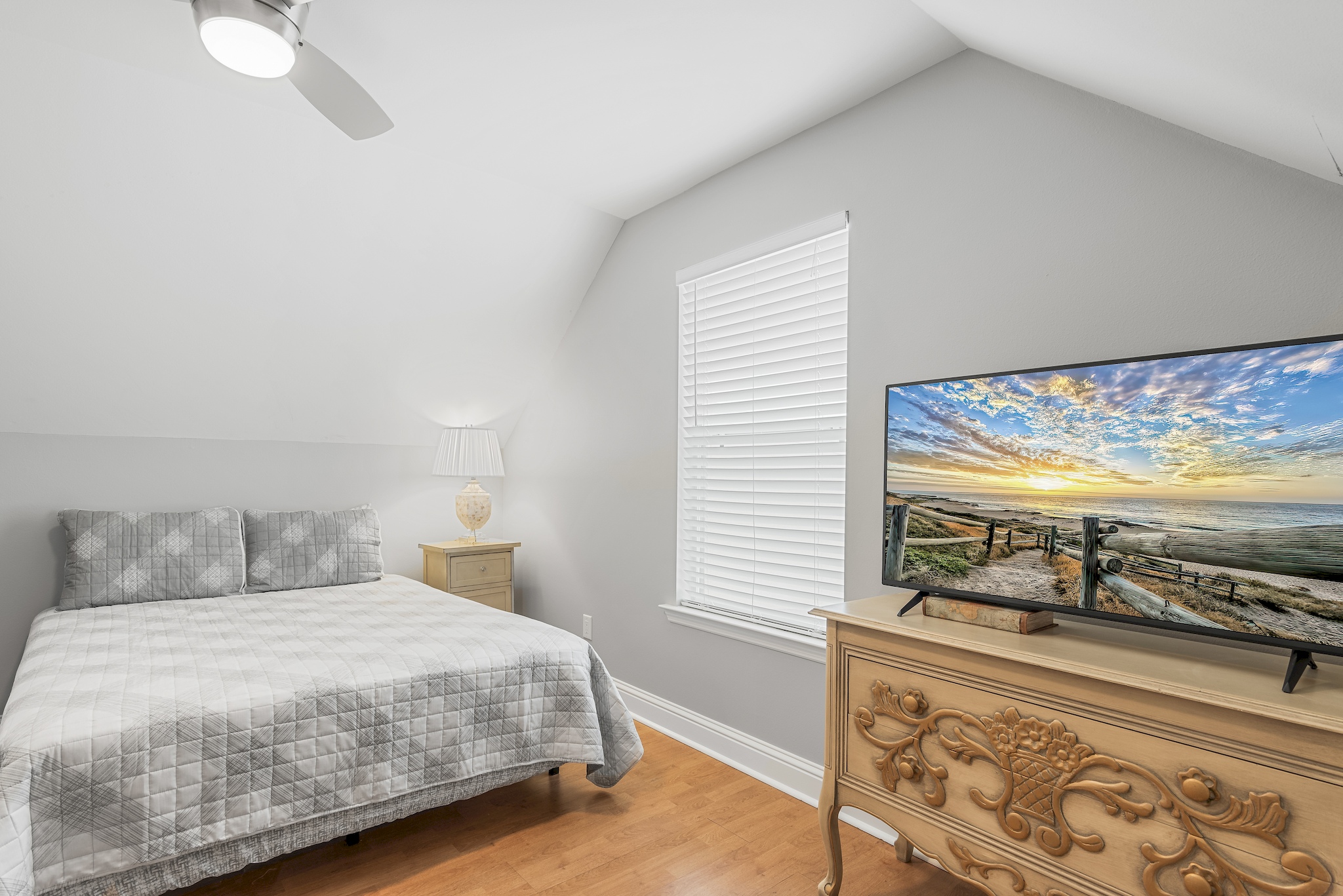 Guest queen bedroom with Smart TV and bright windows