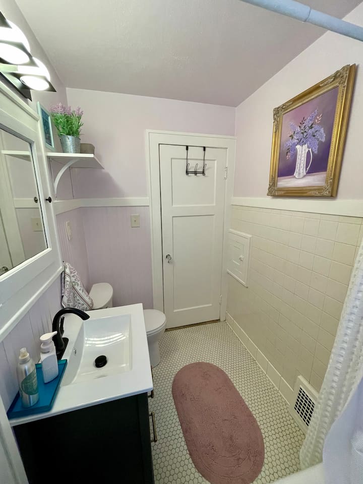 Charming bathroom featuring original tile floors paired with updated fixtures and a light, welcoming feel.