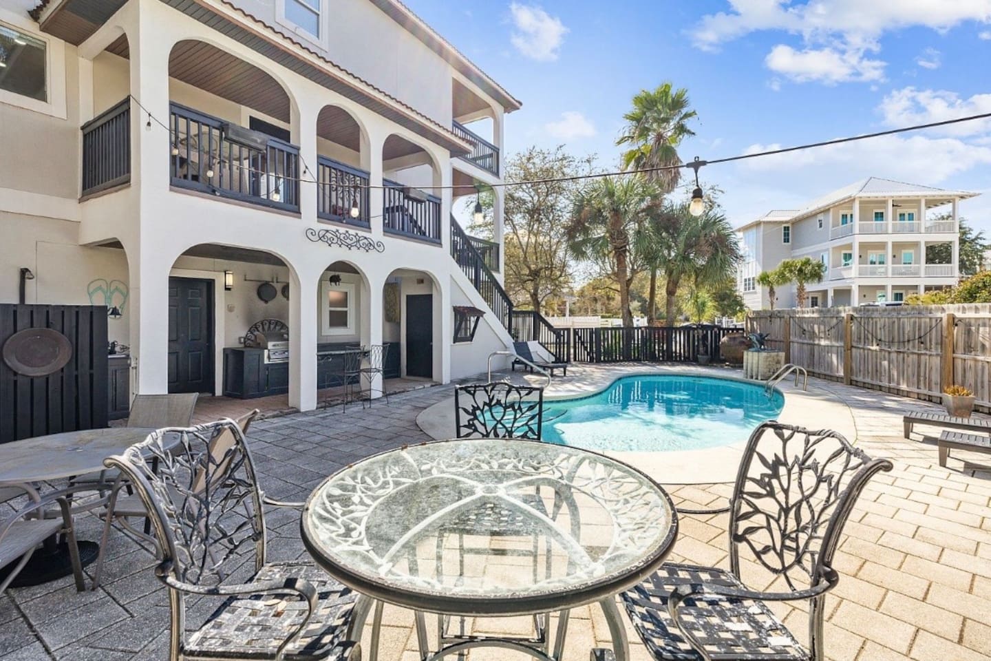 Charming poolside patio and outdoor dining space offering a perfect spot to relax, dine, and soak up the sun during your 30A vacation.