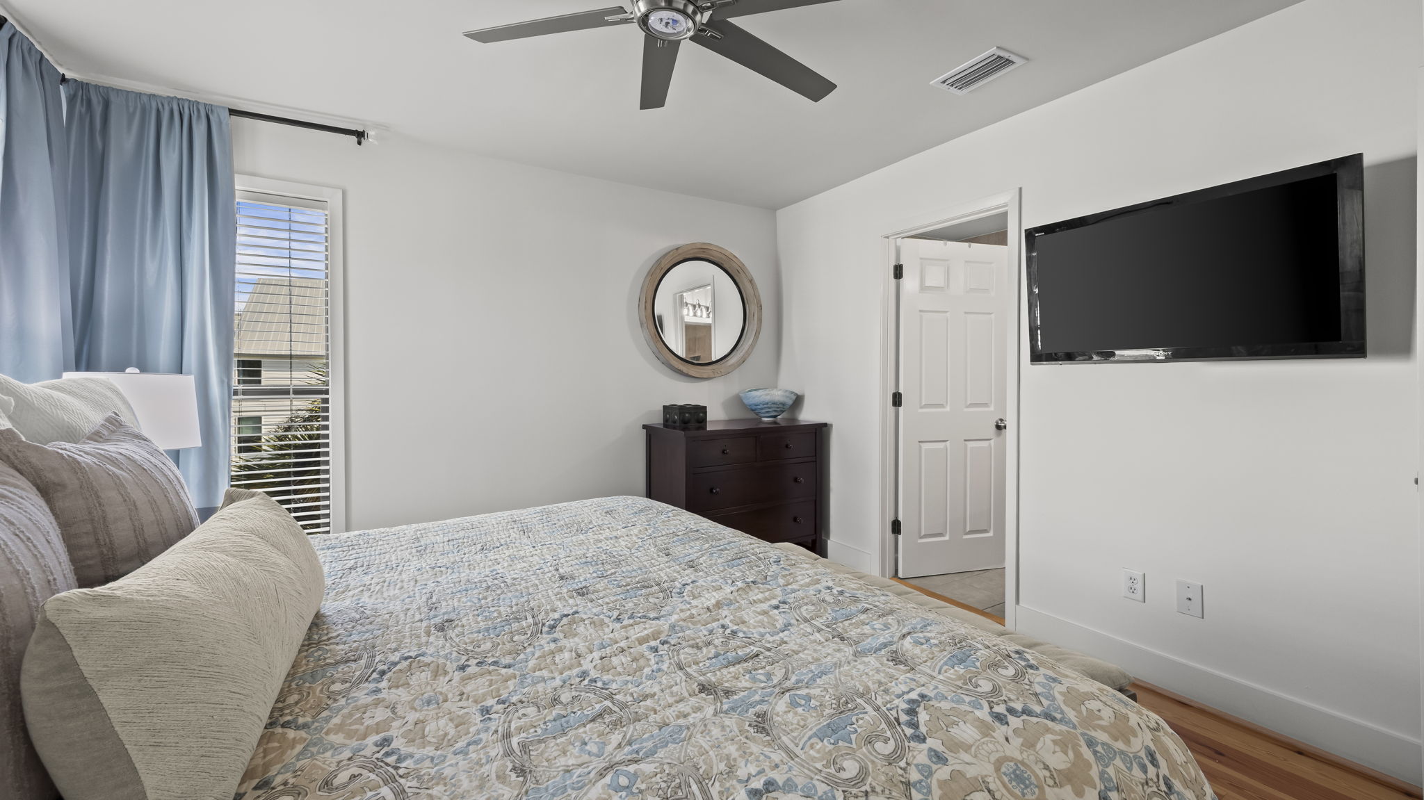 Retreat to the master bedroom of our Cotton Bayou condo, featuring cozy bedding, updated coastal-inspired decor, and a private en suite for ultimate comfort. 