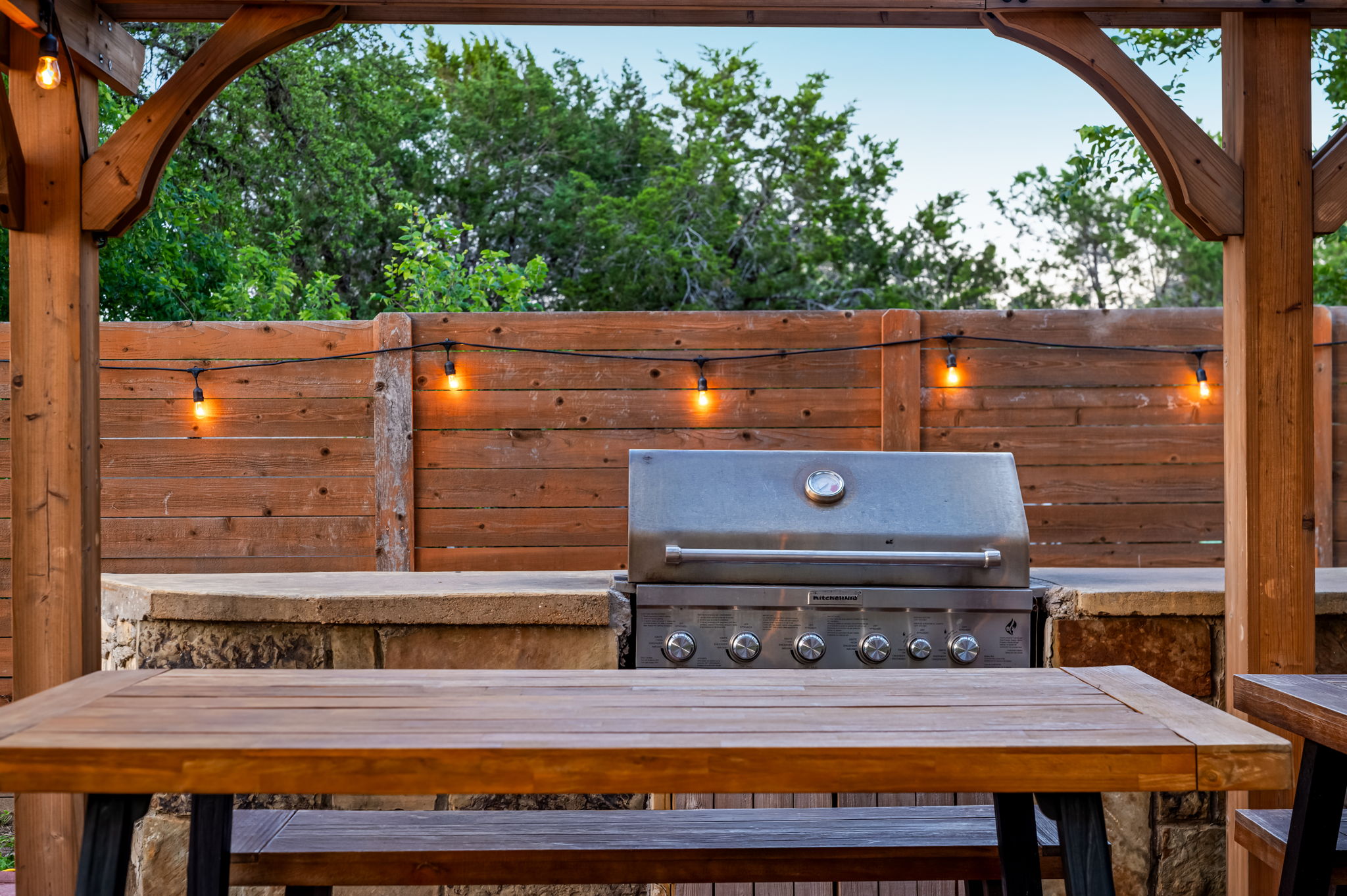 Fire up the grill and enjoy outdoor meals under the covered pergola with string lights and picnic-style seating. A great setup for BBQ nights, family dinners, and relaxing evenings outdoors.