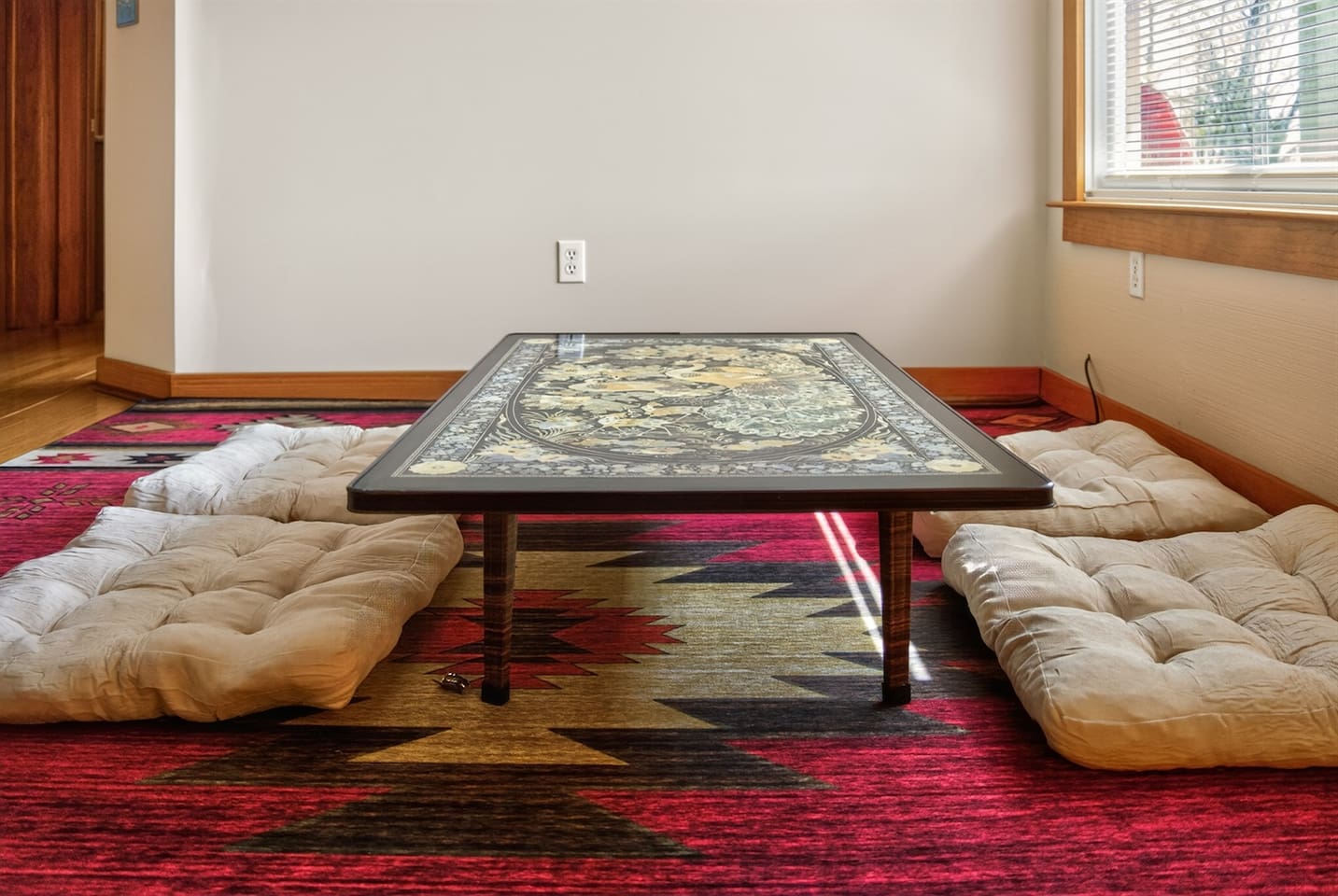 Relax in a Japanese-style living room with a low table, floor seating cushions, and warm, calming design—perfect for tea, conversation, or quiet moments, blending comfort and culture into a unique, peaceful retreat experience