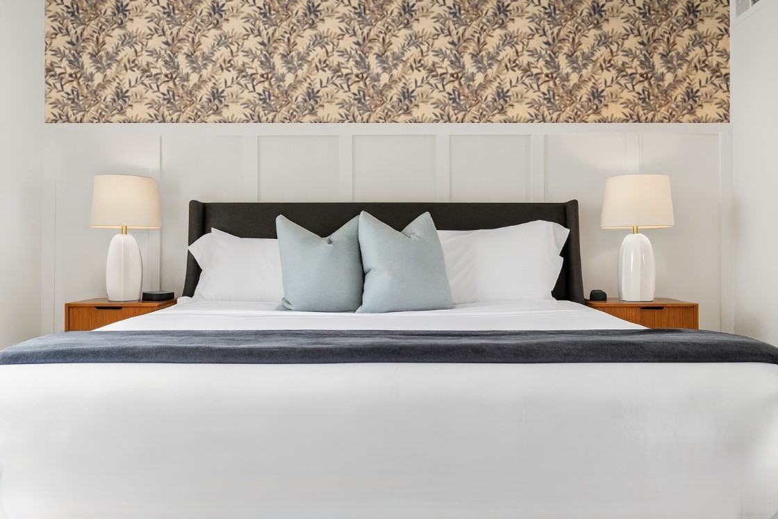 Rest easy in a plush king bed with stylish lighting, soft linens, and a relaxing atmosphere.
