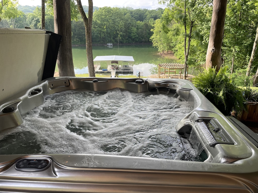 Hot tub with waterfall.  view of lake, tv, bar and patio