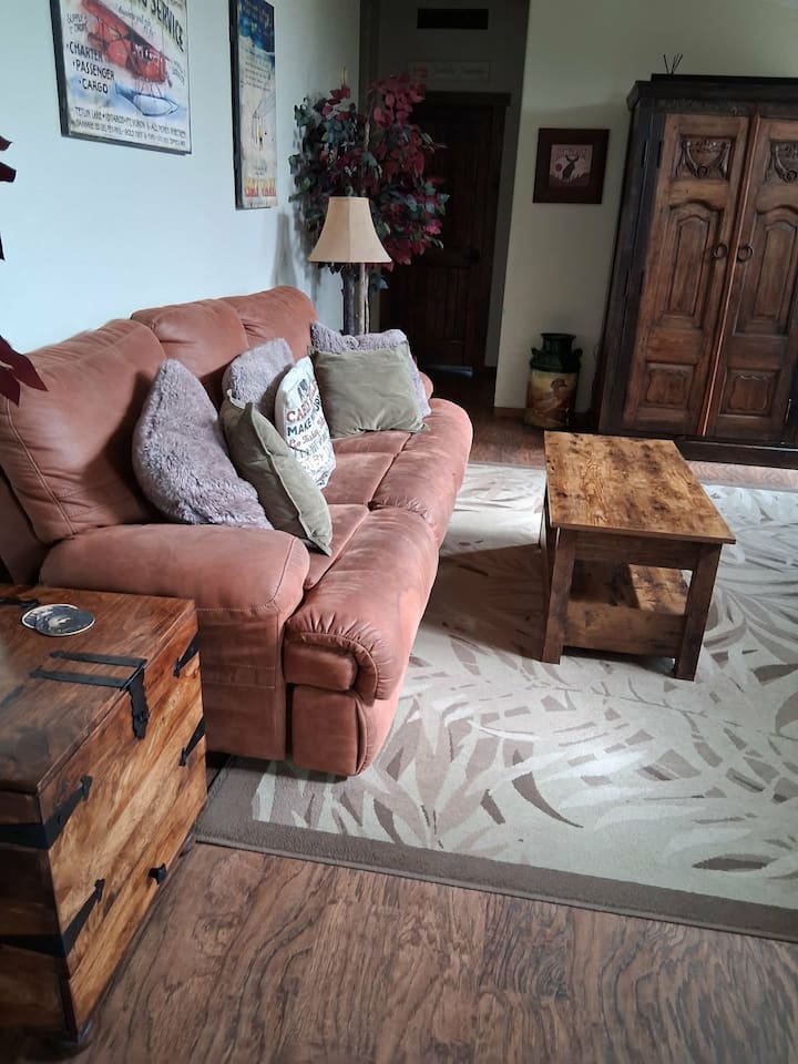 Reclining sofa in the second living area with the woodstove and massage chair and an armoire full of family friendly games and DVDs