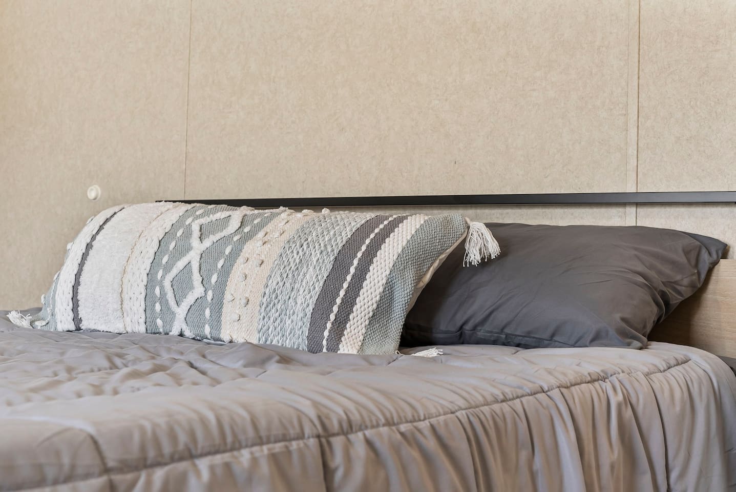Close-up of the bed showcasing soft linens and stylish accent pillows for a restful night’s sleep.