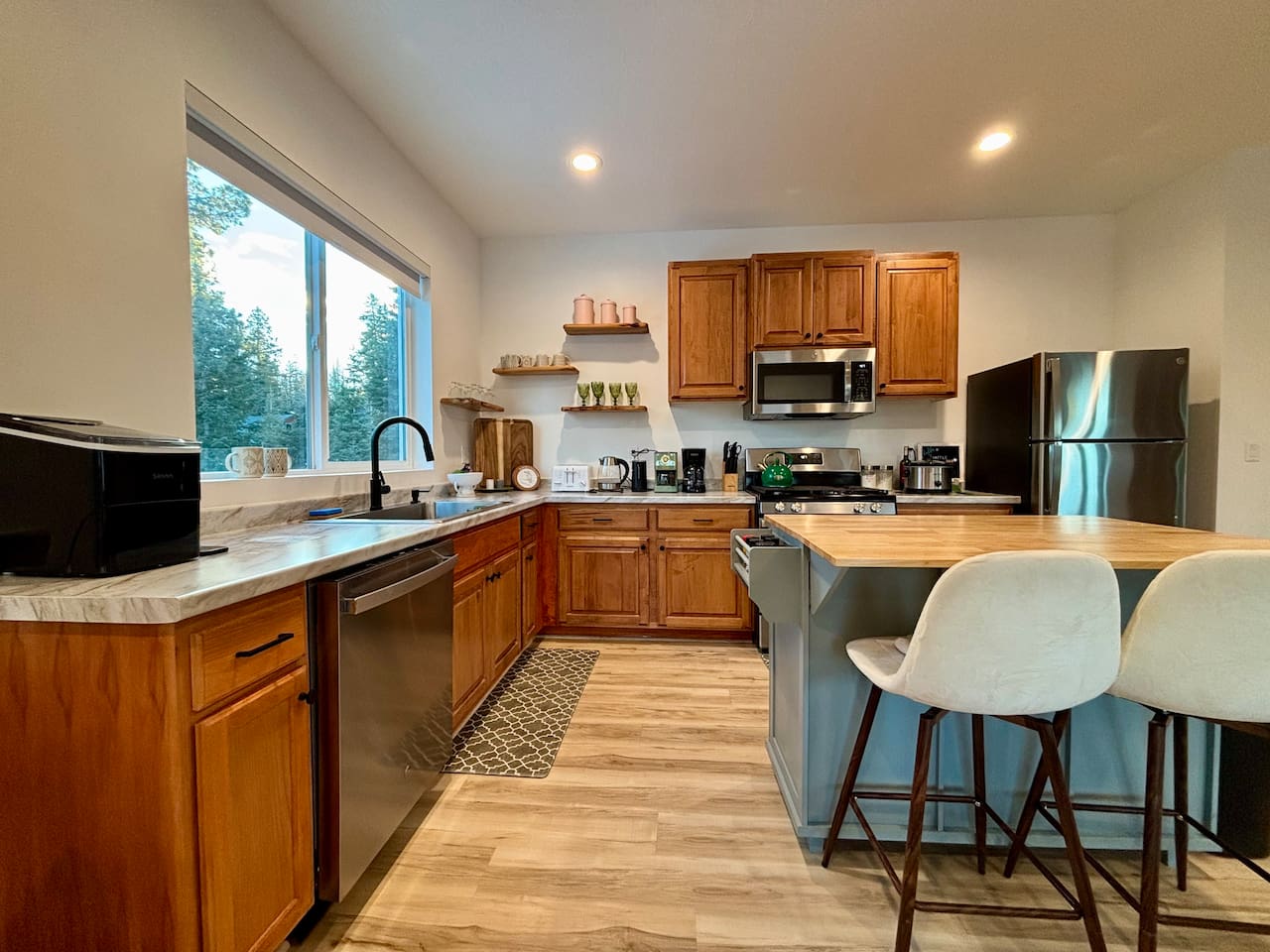 A clean, welcoming kitchen with thoughtful touches and a peaceful view of the trees. ✨