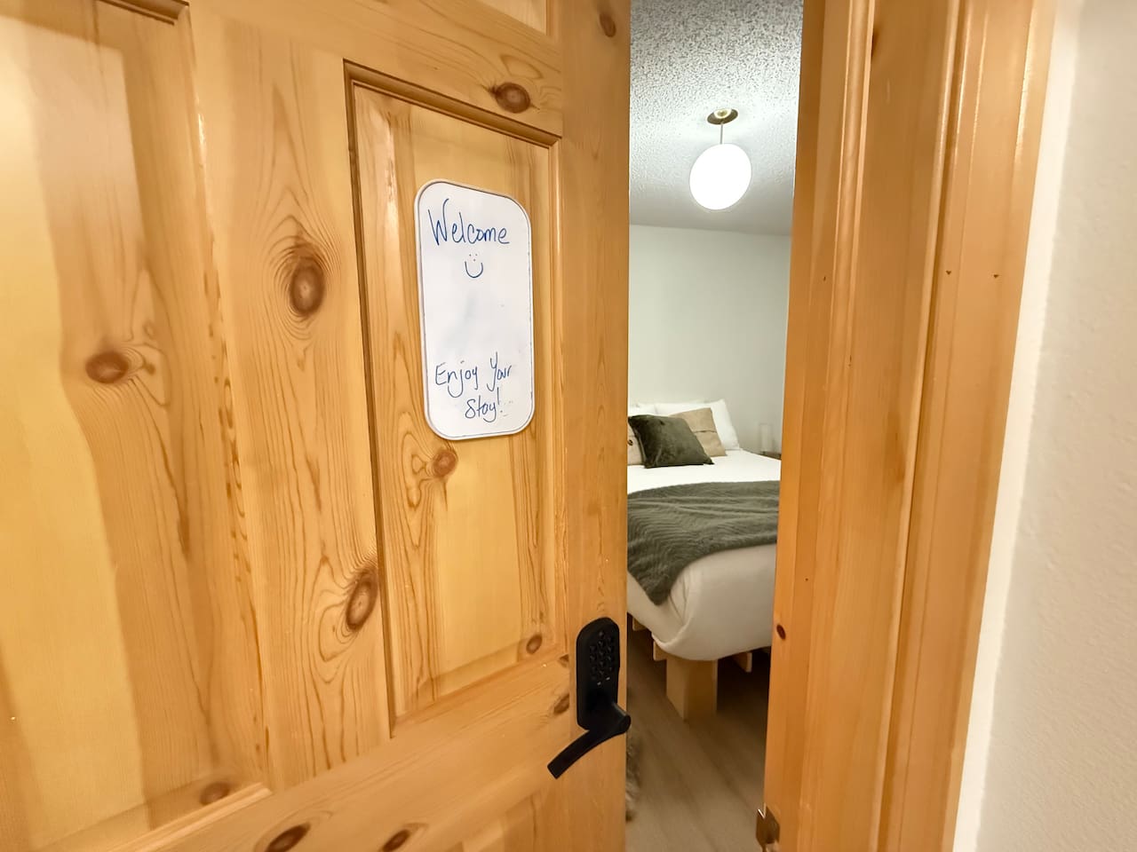 Main Floor Bedroom Entryway: View of the main floor bedroom entry and en-suite bathroom access, highlighting the natural wood accents.