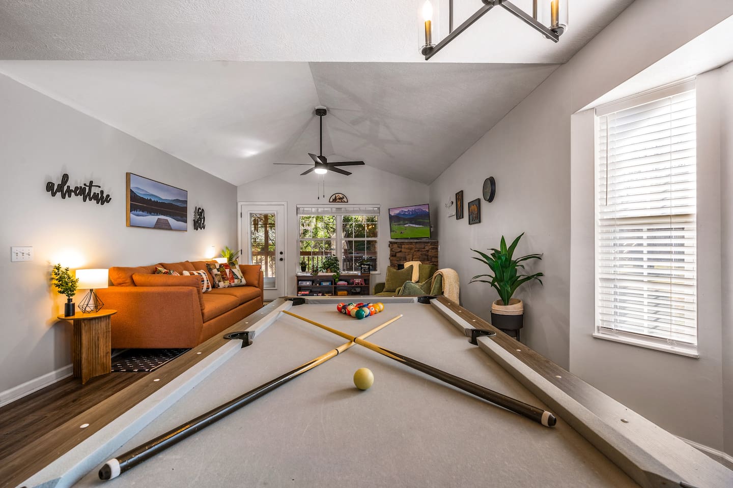 This cozy game room features a full-size pool table, comfy seating, and a fireplace—perfect for relaxing or enjoying a game night. Bright, inviting, and full of charm!