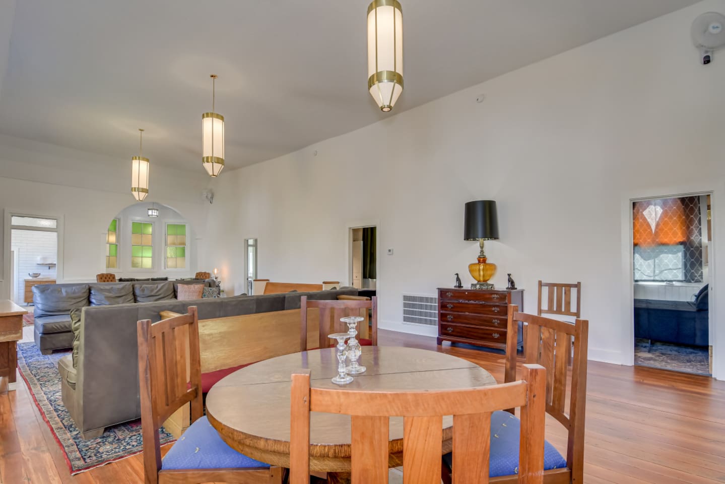 Dining and lounge area with cathedral windows and wood floors.