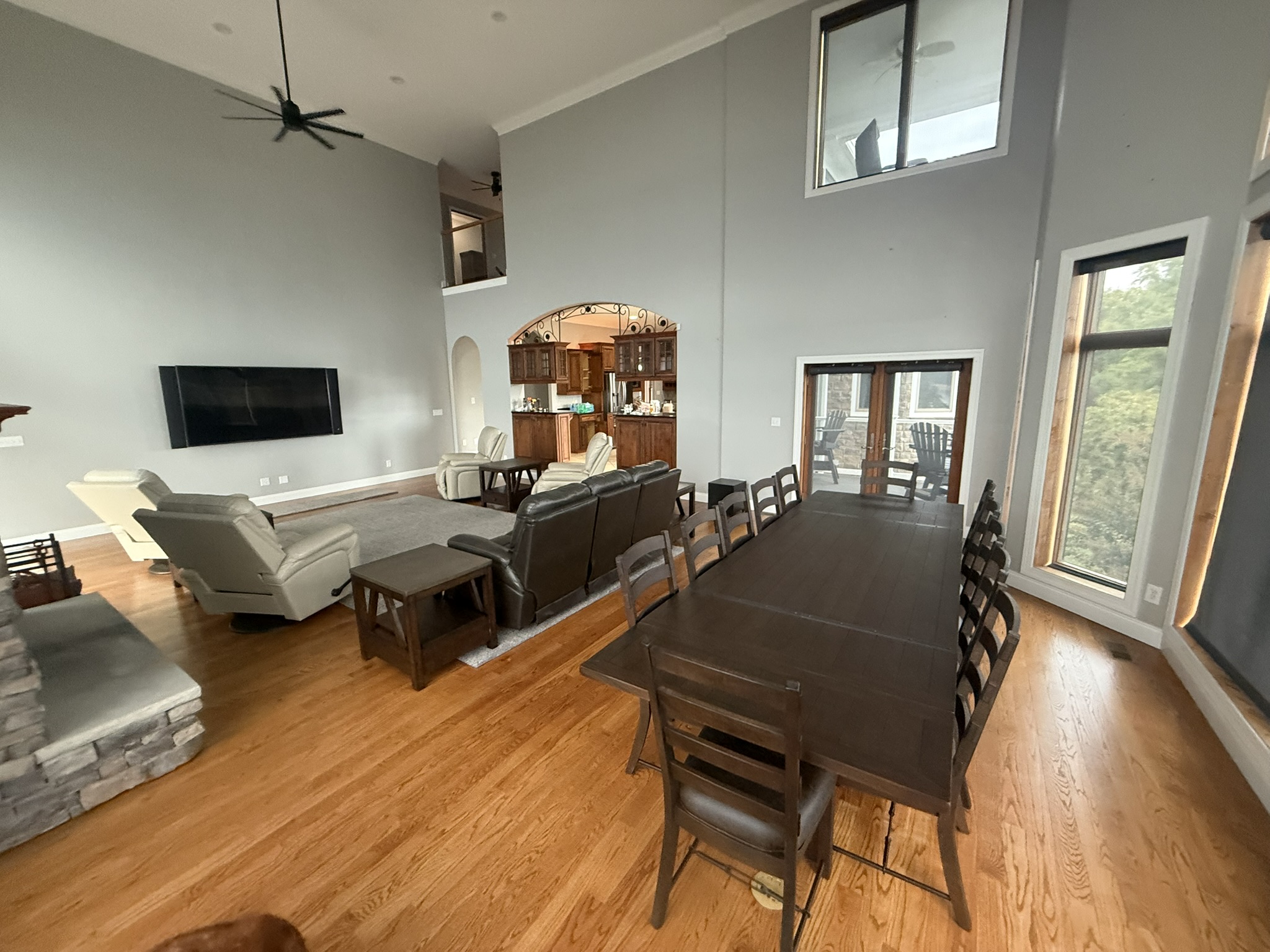 The living room is equipped with top-quality TV, a Stone wood-burning fireplace, and access to a back and front covered porch shared with the kitchen