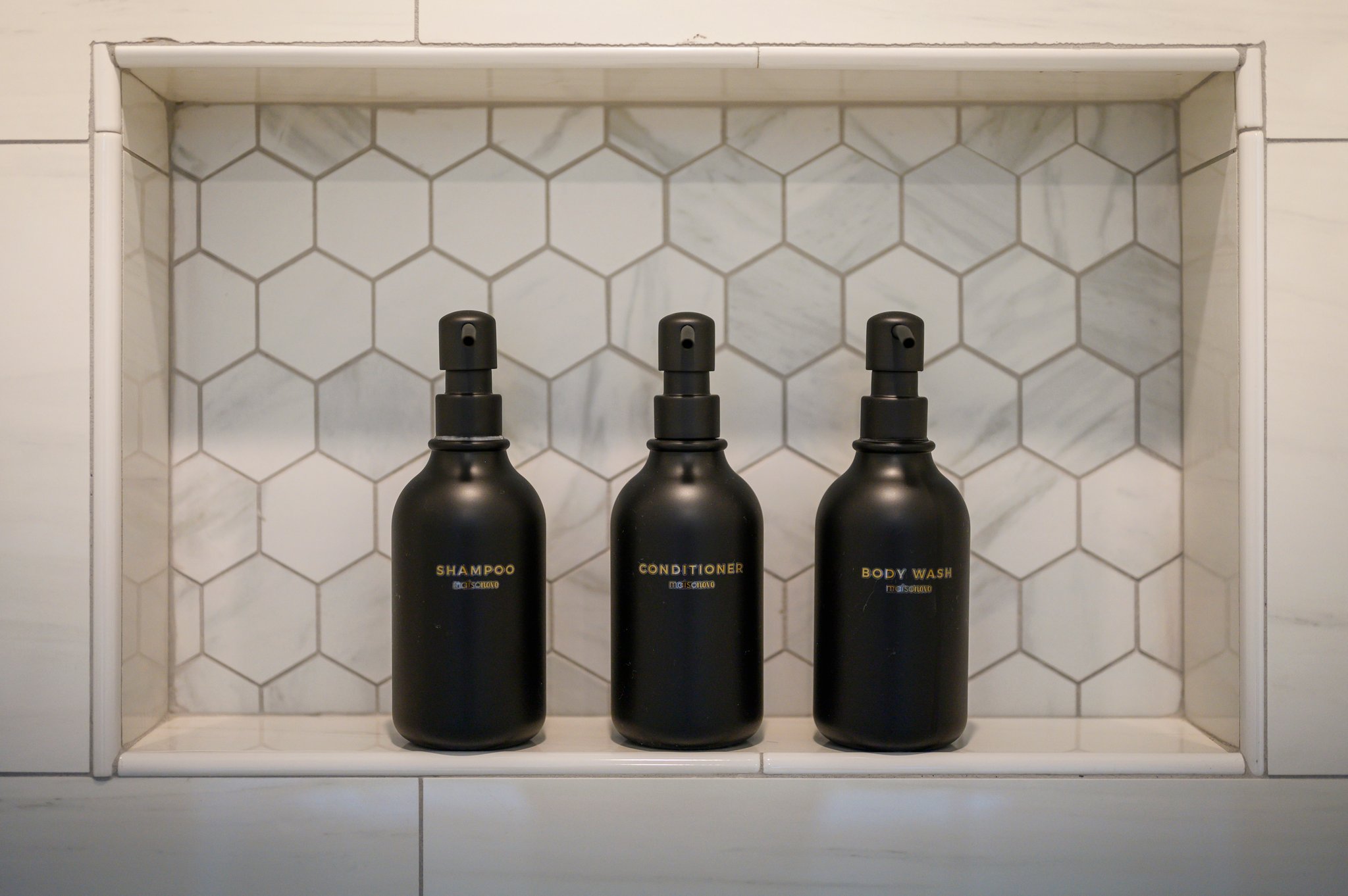 A built-in shower niche keeps premium toiletries neatly organized for a clean, spa-like experience.