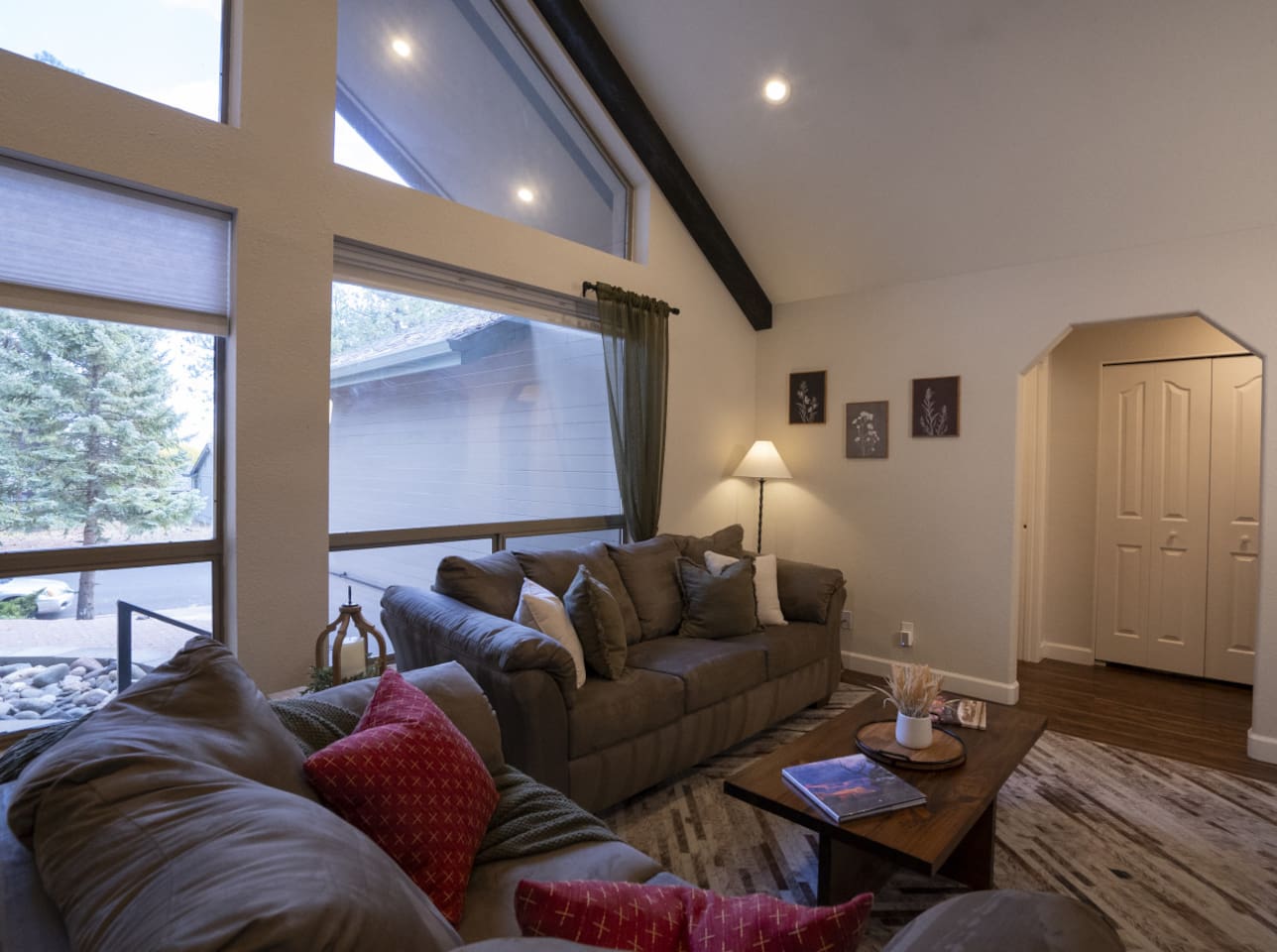 Open living space with tall windows, natural light, and a cozy setup for gathering after a day out.