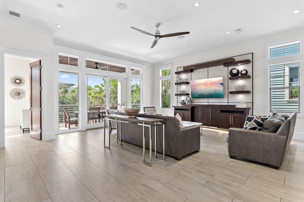 A spacious living area with comfortable seating, a Smart TV, and balcony views overlooking the pool
