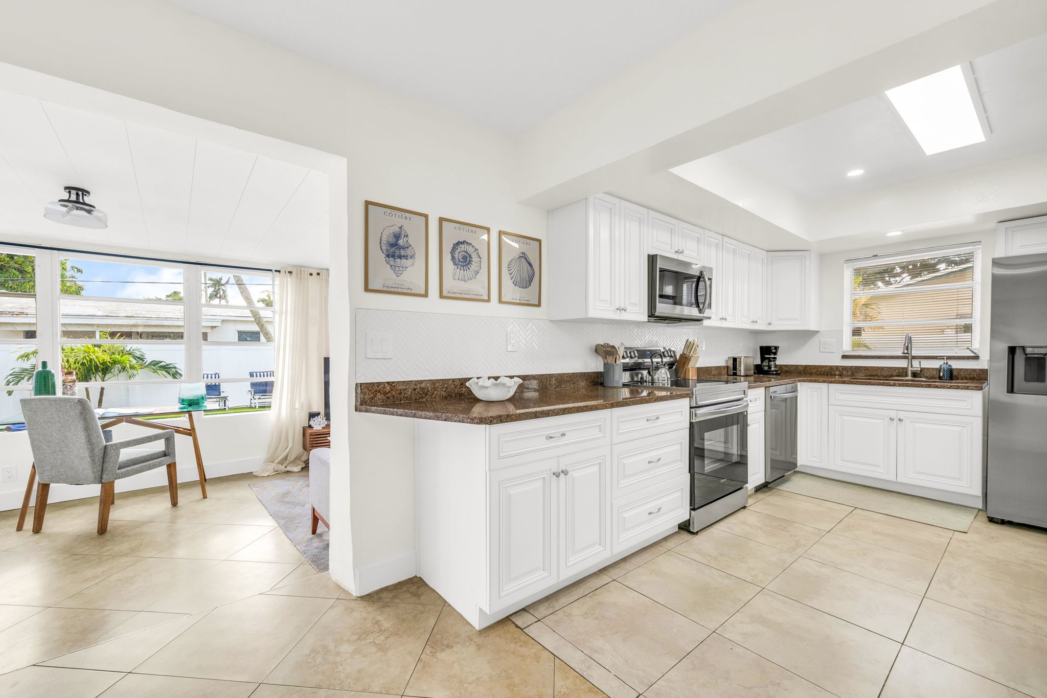 A spacious, light-filled kitchen offering stainless steel appliances, rich countertops, extensive cabinetry, and thoughtful amenities such as a coffee maker, blender, and toaster for effortless cooking and entertaining.
