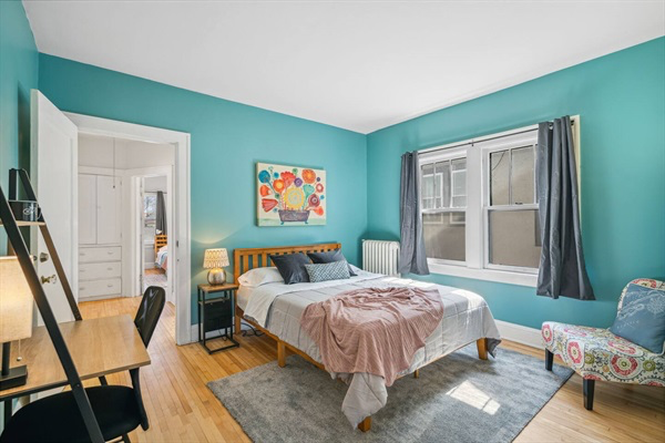 Teal front room. Cozy queen bed, desk and chair for some get away space!