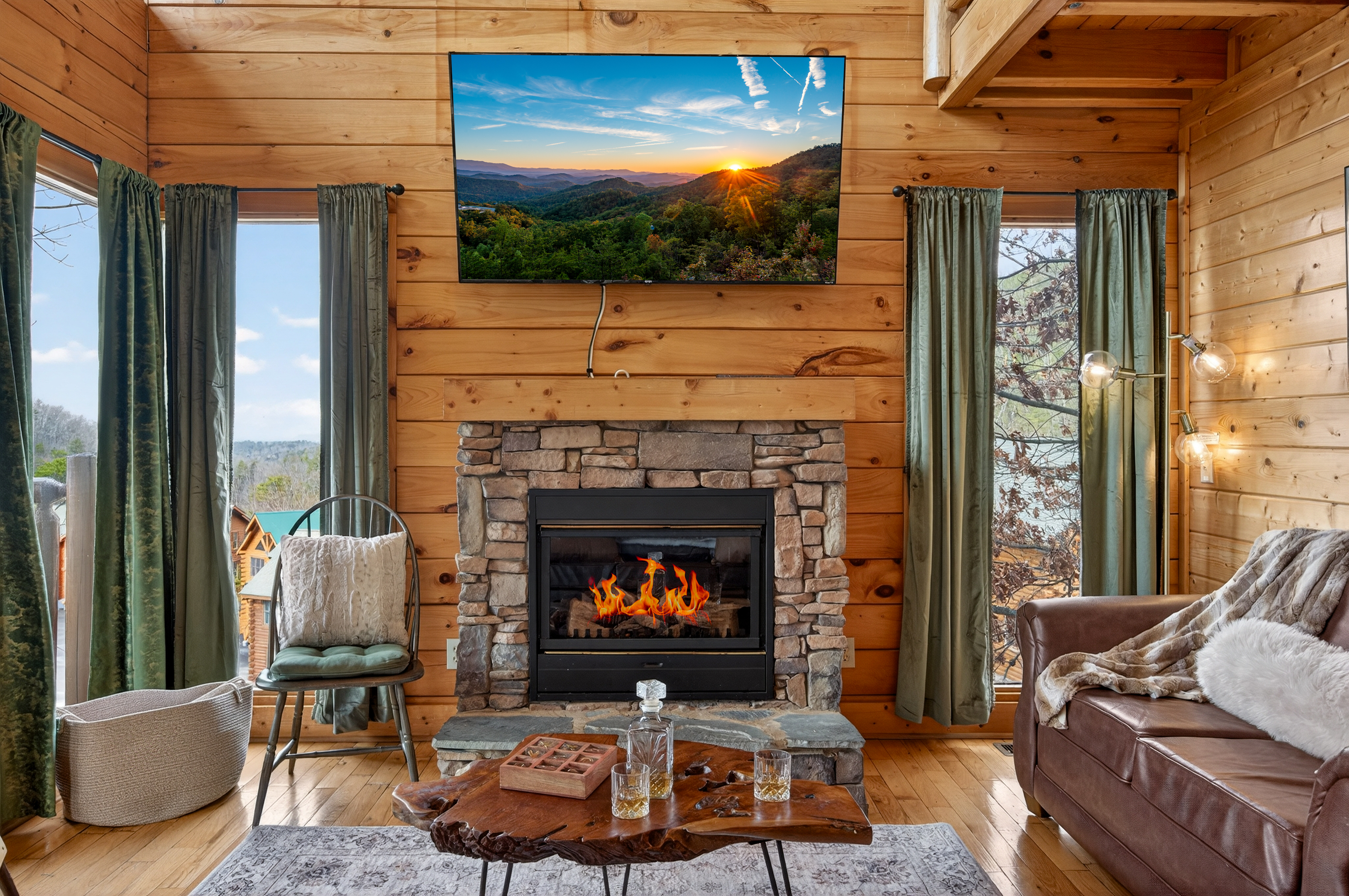 Stone fireplace, Smart TV, and a whiskey on the hearth — the main living room is the kind of place you sit down and suddenly it's midnight