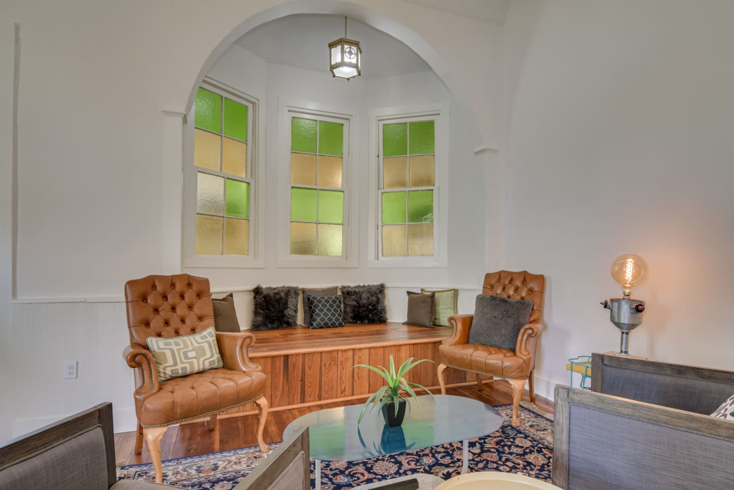 Vintage lounge with patterned rug and original wood trim.