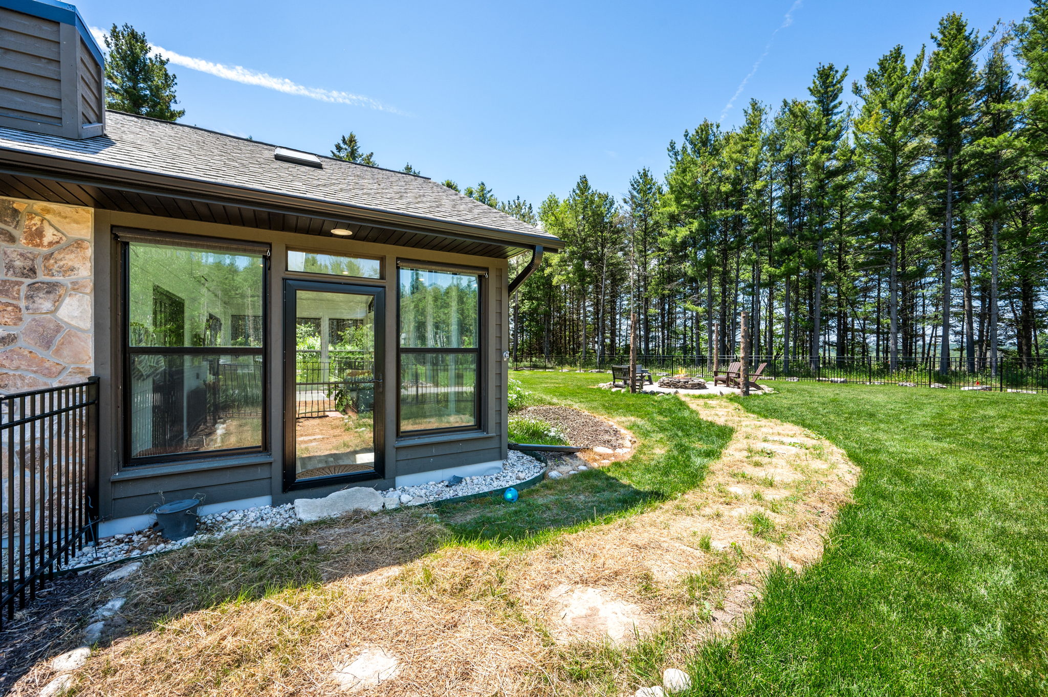 Wander the private grounds along a stone path that leads from the sunroom to the backyard fire pit and endless pine forest.