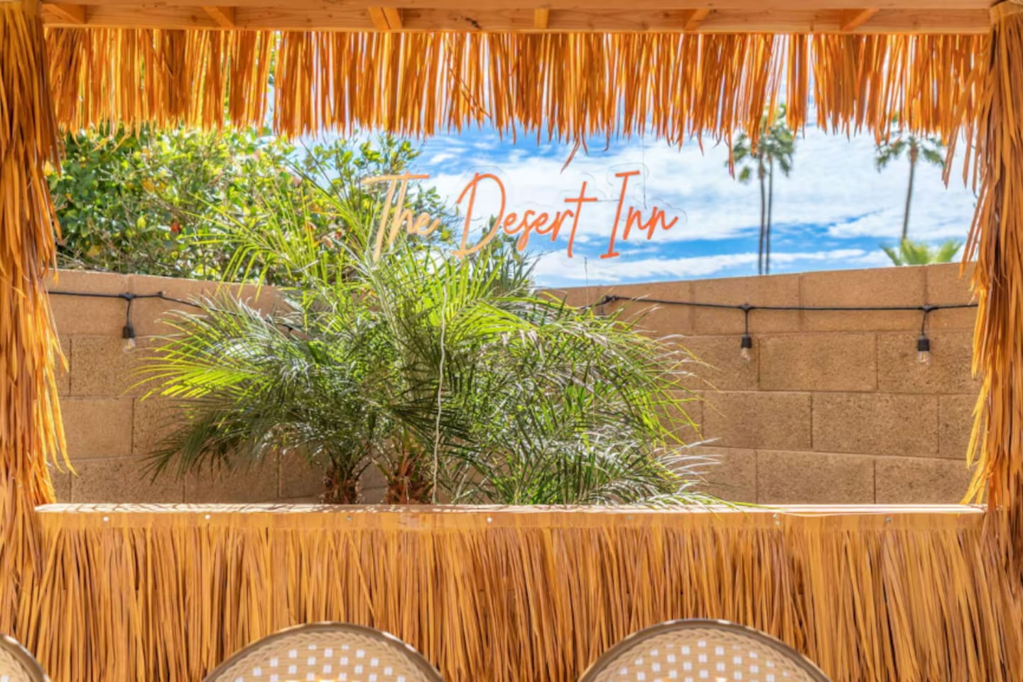 Tropical tiki bar with thatch roof, desert views, and signature branding—the ultimate outdoor hangout space.